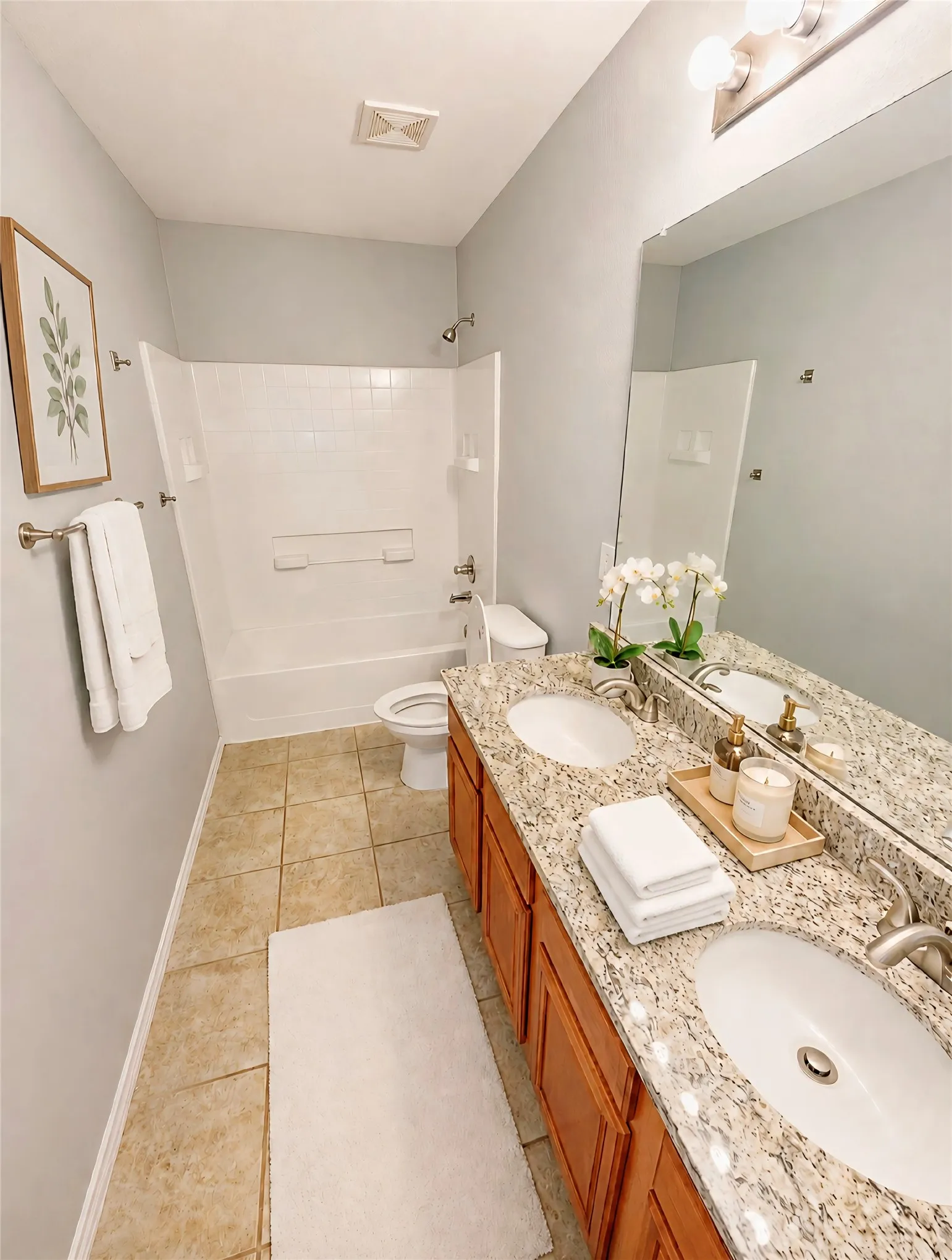 Dual sinks with granite countertop, wood-finish cabinetry, new faucets.