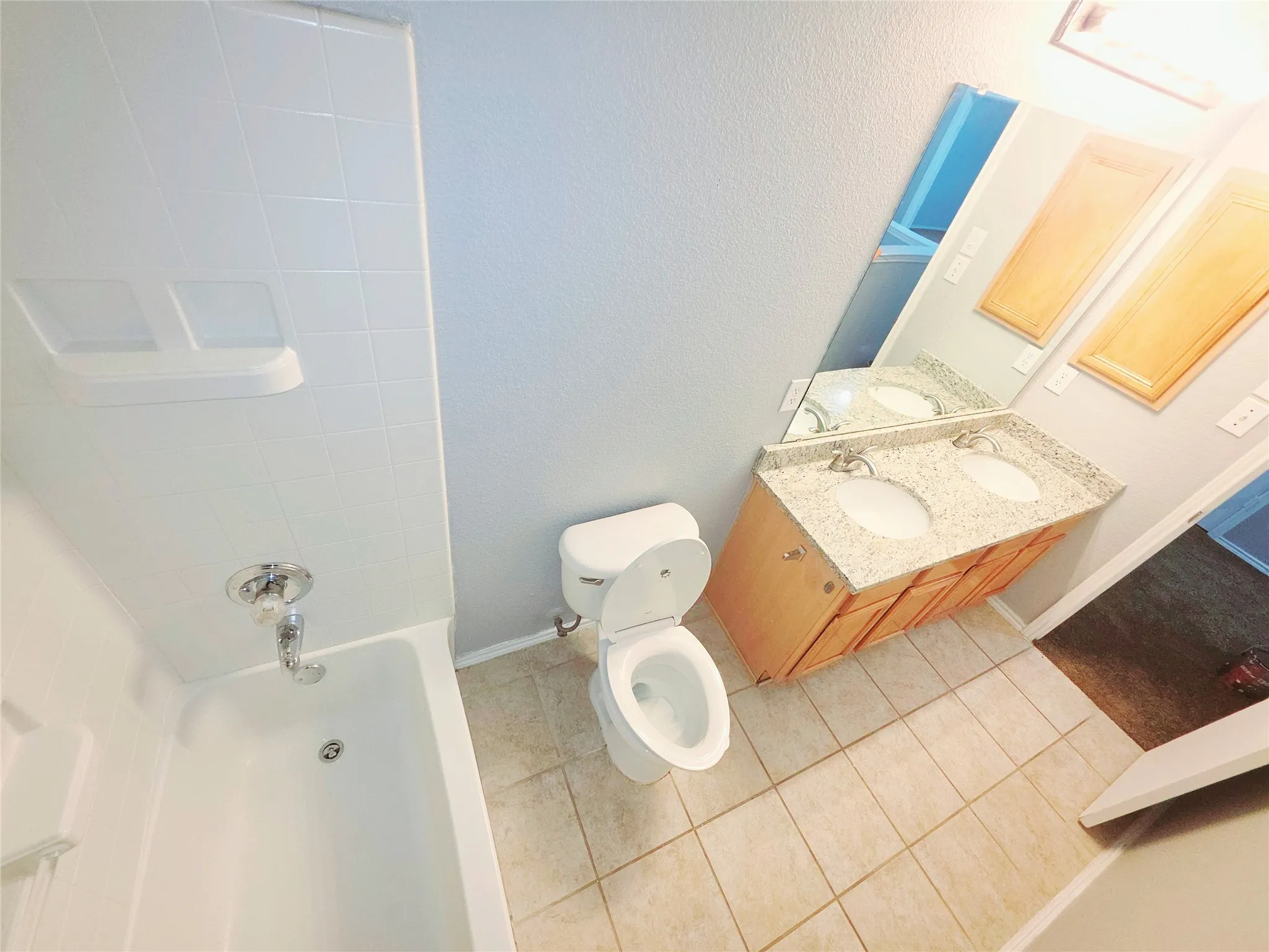 Dual sinks, with granite countertop, and wood-finish cabinetry