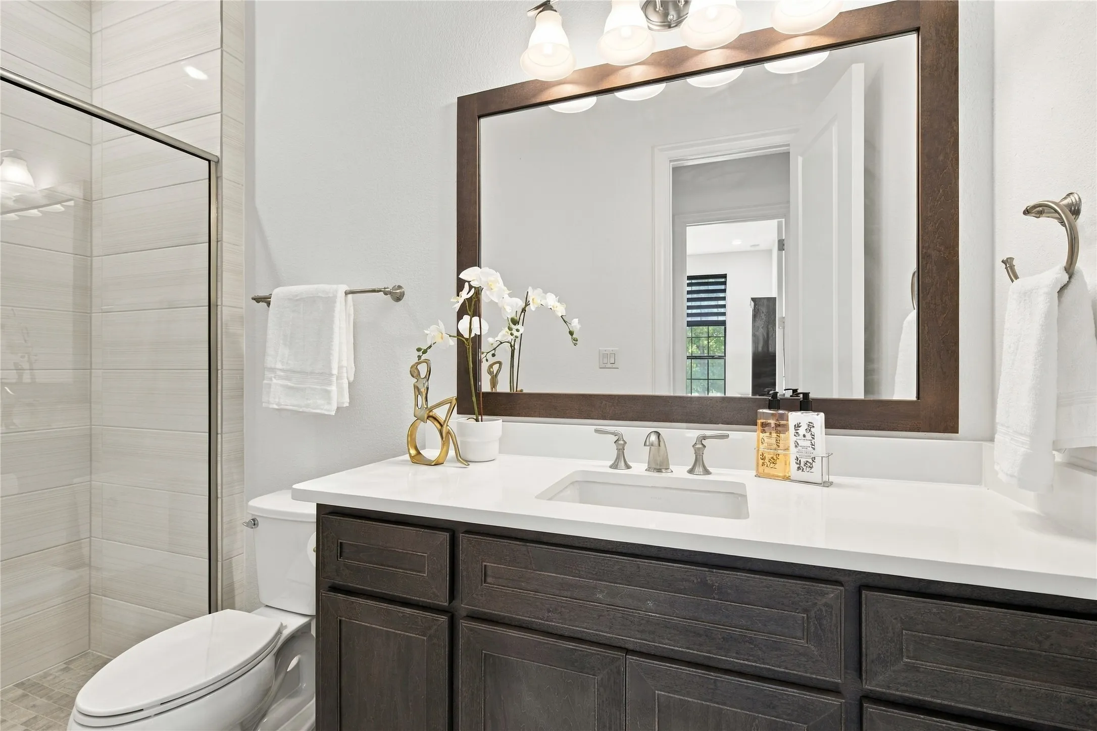 Bathroom with walk in glass shower.