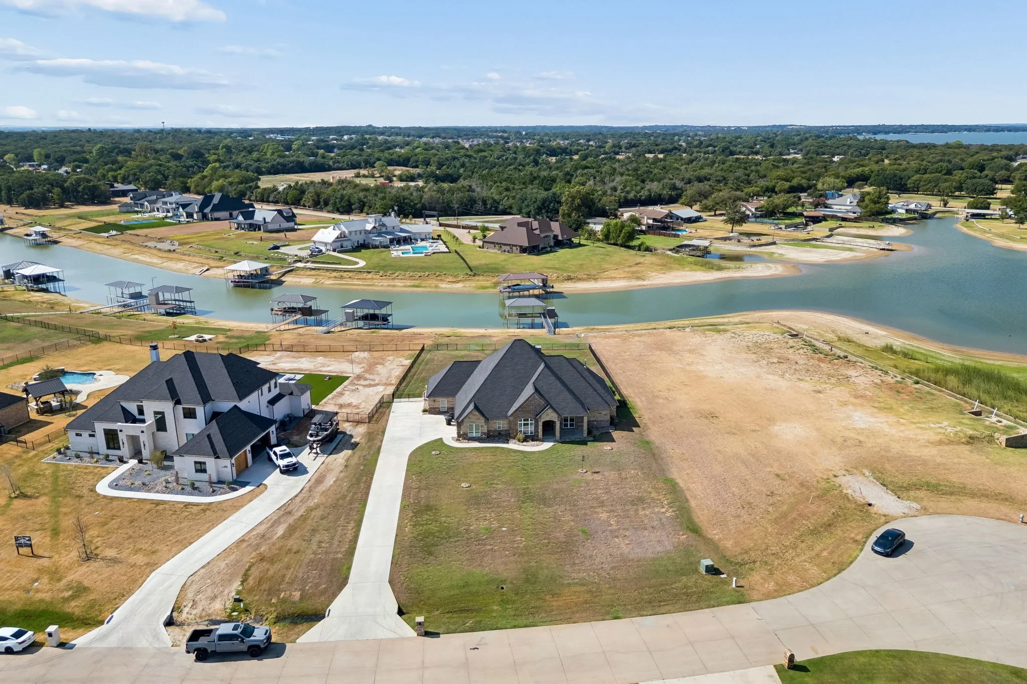 Waterfront property featuring a private boat dock, concrete driveway, and a two-car garage