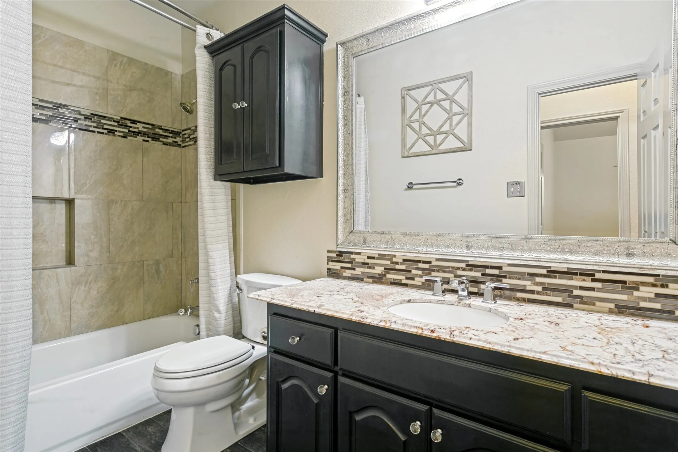Bathroom featuring a vanity with granite-style countertop, undermount sink, and dark wood-finish cabinetry
