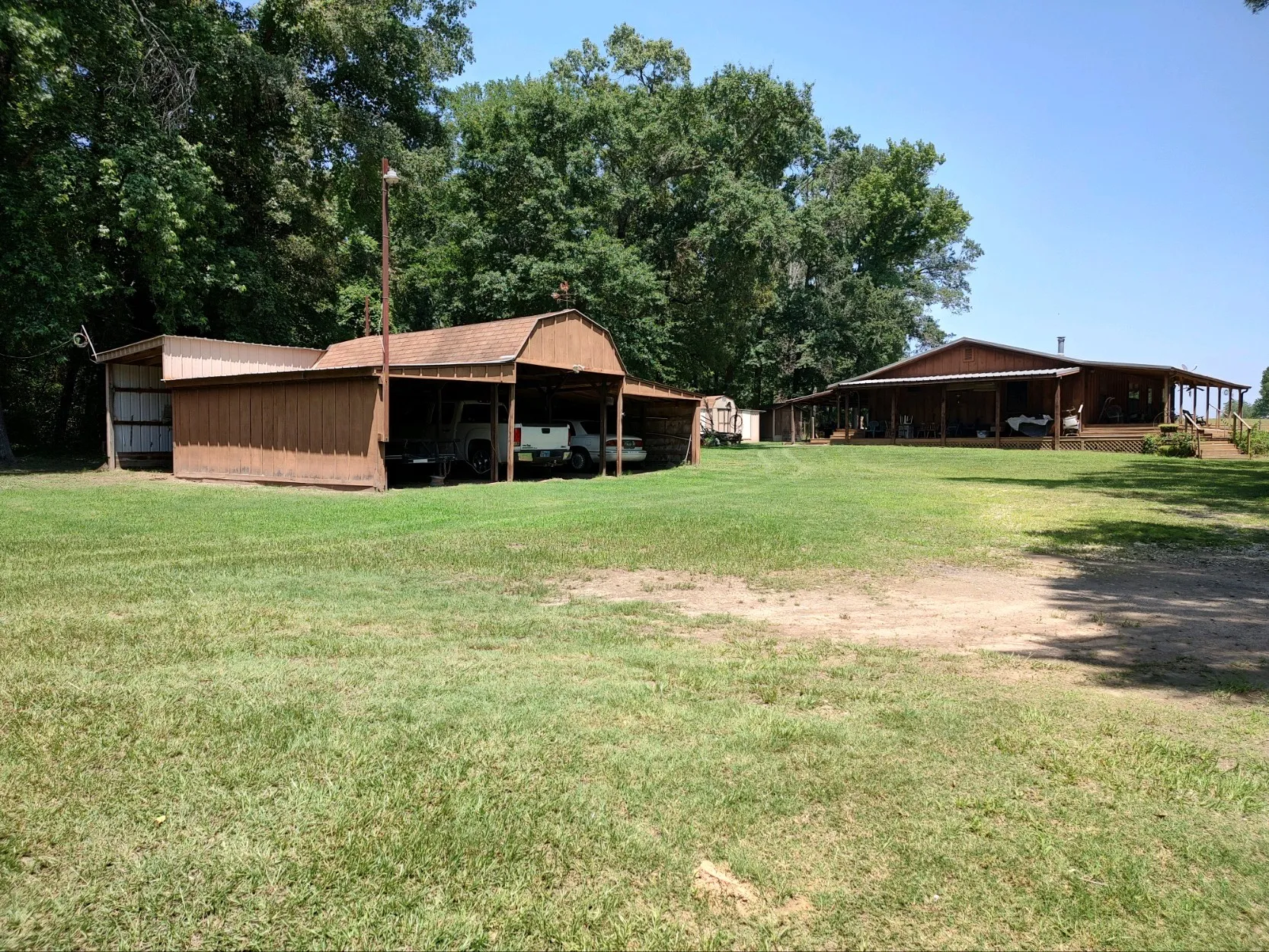 Three-car carport with electricity, loft, and attached shedrow.