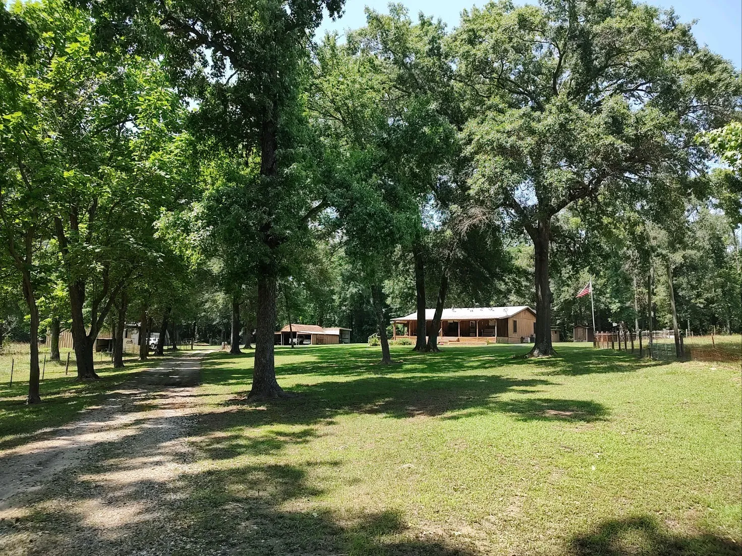 Street view of property with covered porch, and deck, 3-car carport in background.