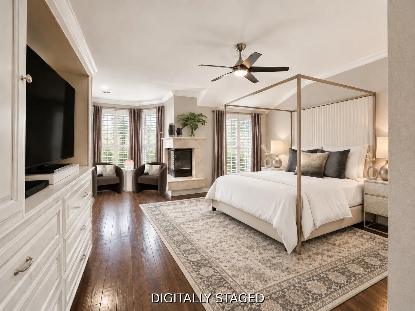 Built-in media cabinetry, wood-finish flooring, bay window with plantation shutters, ceiling fan, and a fireplace with a stone surround