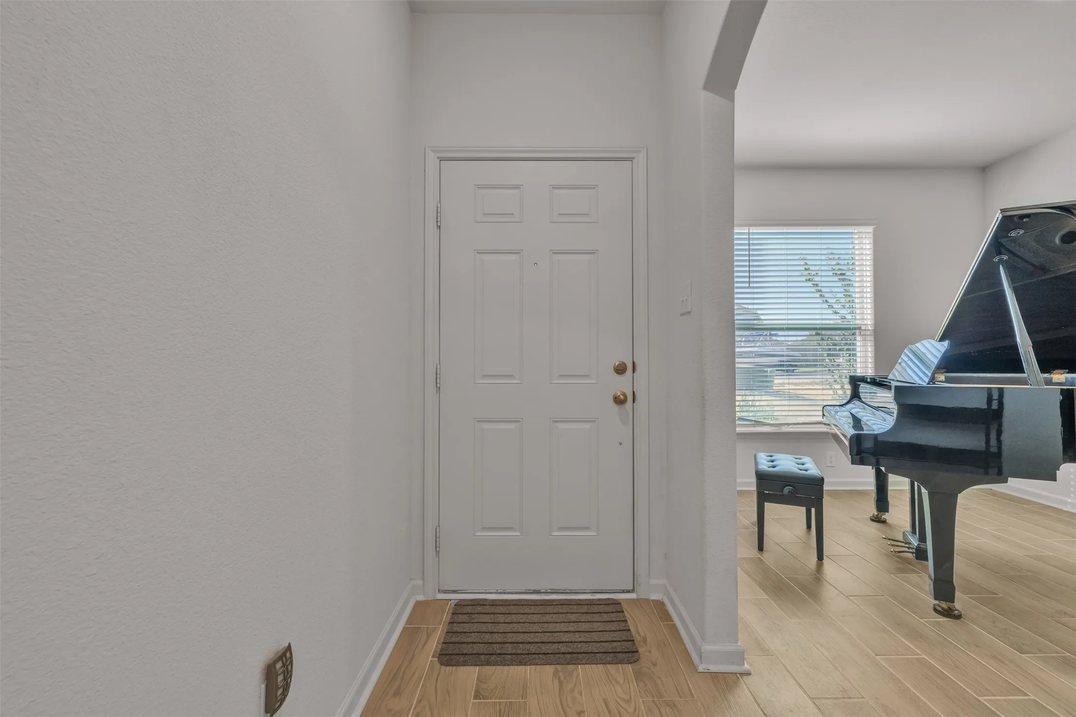 Entryway with wood-finish flooring and a multi-paneled door
