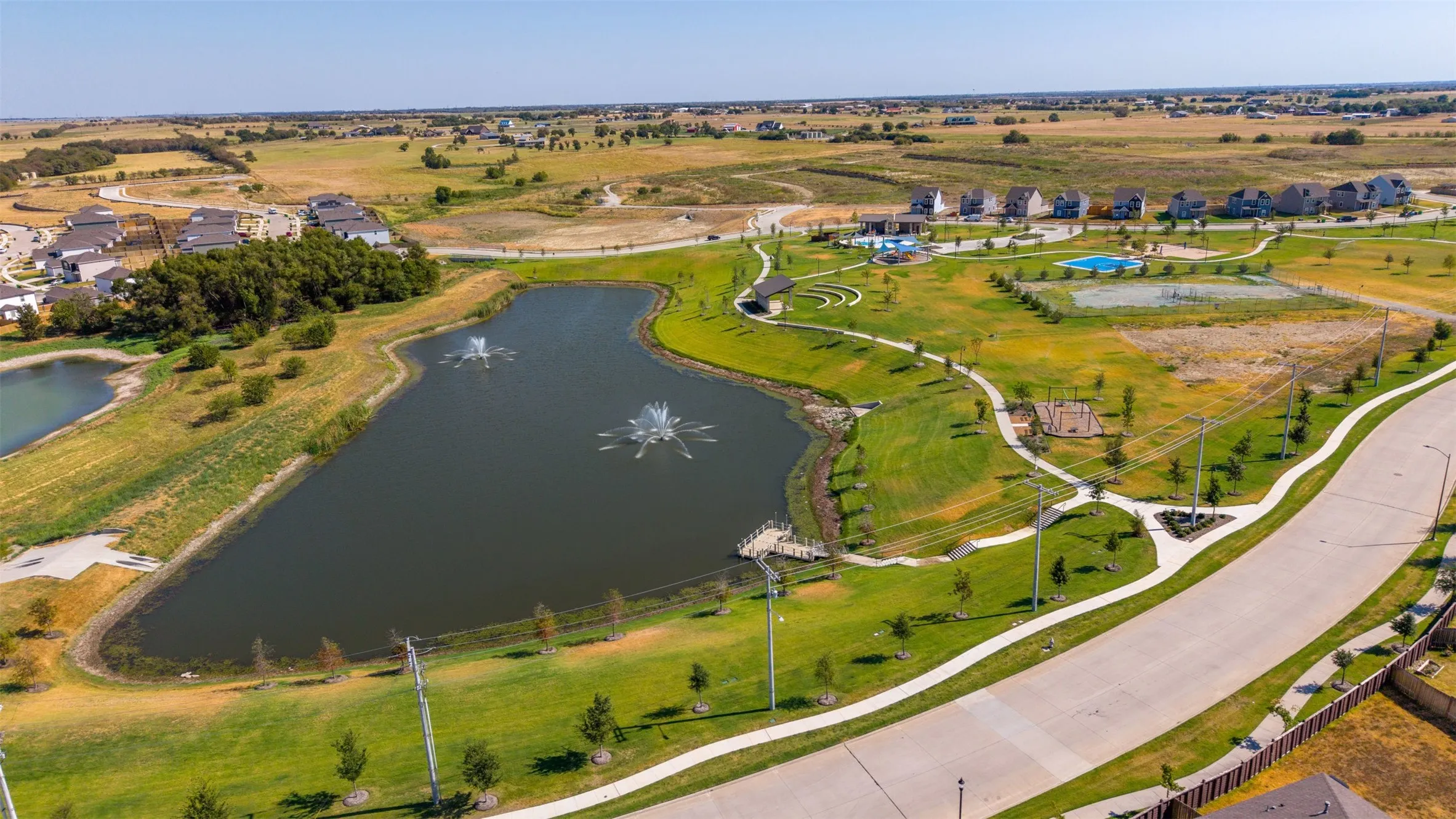 Community lake with water features, walking paths, recreational areas, and a community pool