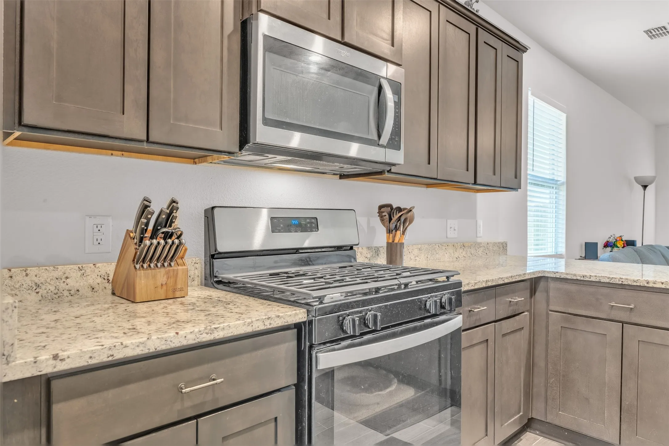 Kitchen featuring stainless steel appliances, granite countertops, and wood-finish cabinetry