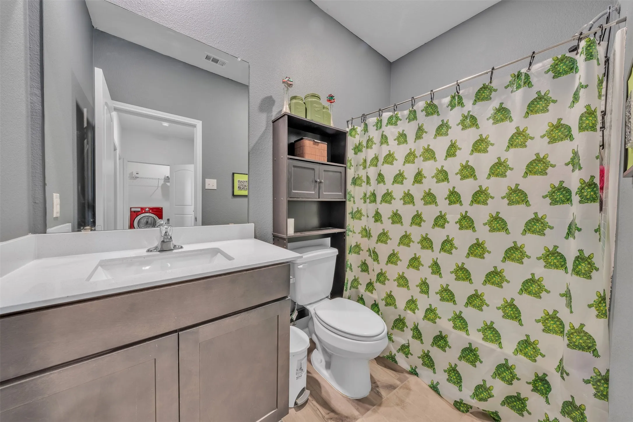 Bathroom featuring a single vanity with an integrated sink, polished chrome faucet, and a large wall-mounted mirror