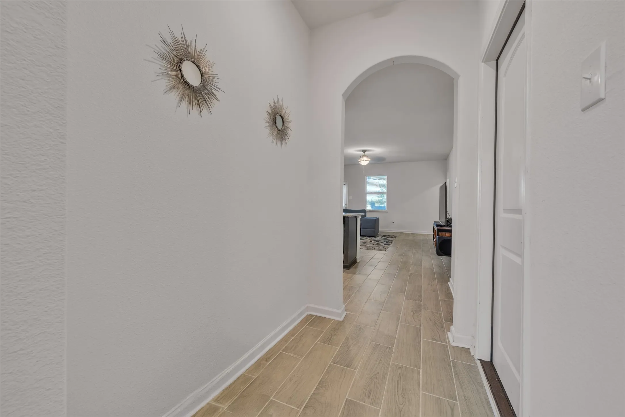 Archway entry leading to main living area with wood-finish flooring