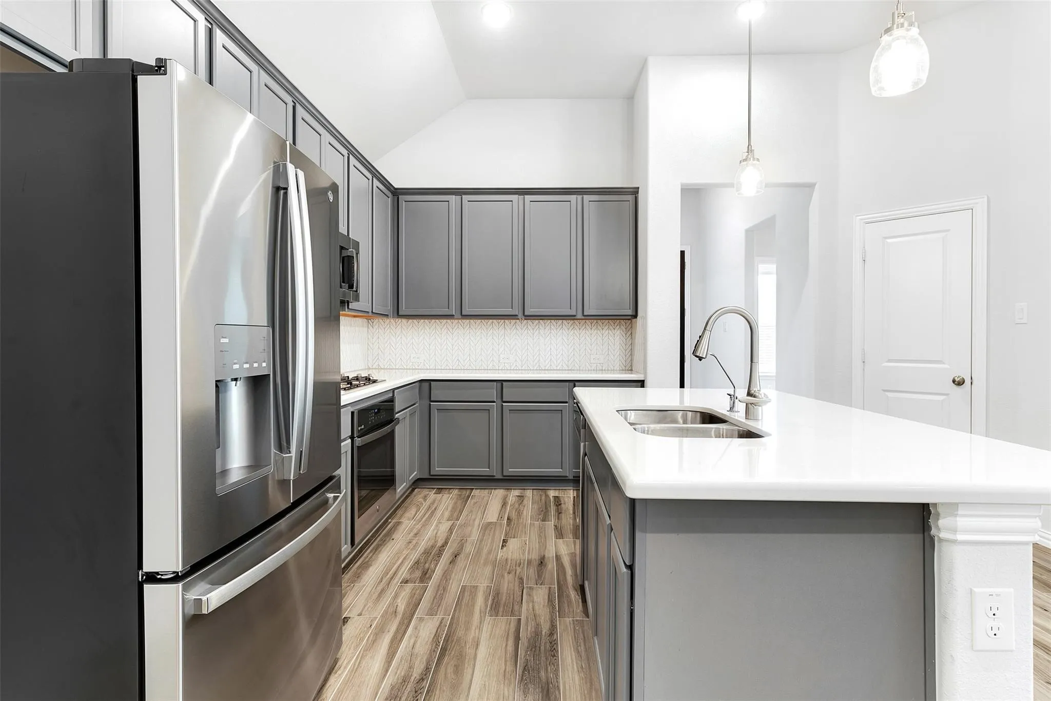 Stainless steel appliances, oversized kitchen island with bar seating, and plenty of cabinet space
