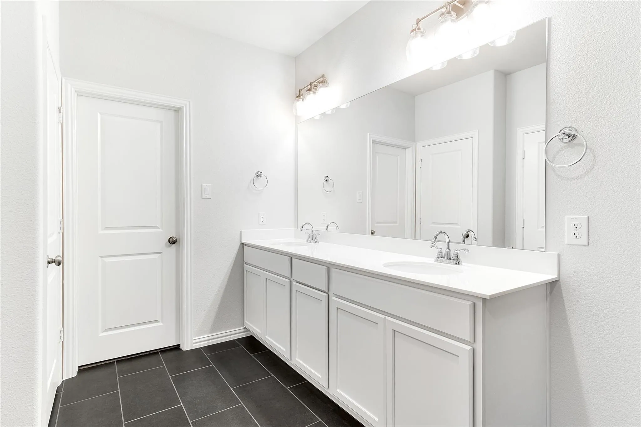 Primary bathroom with oversized shower, dual sinks, and separate linen closet