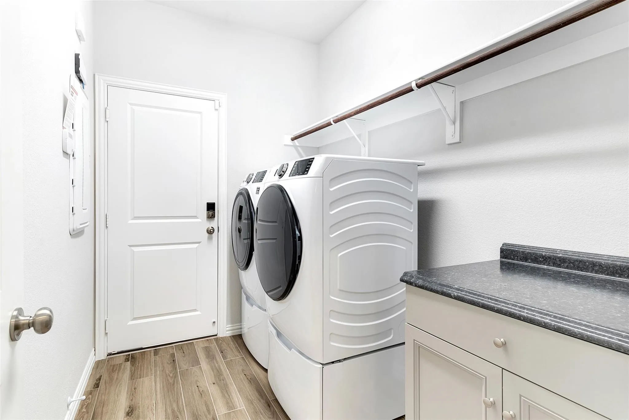 Laundry room with extra shelving and cabinet space for storage