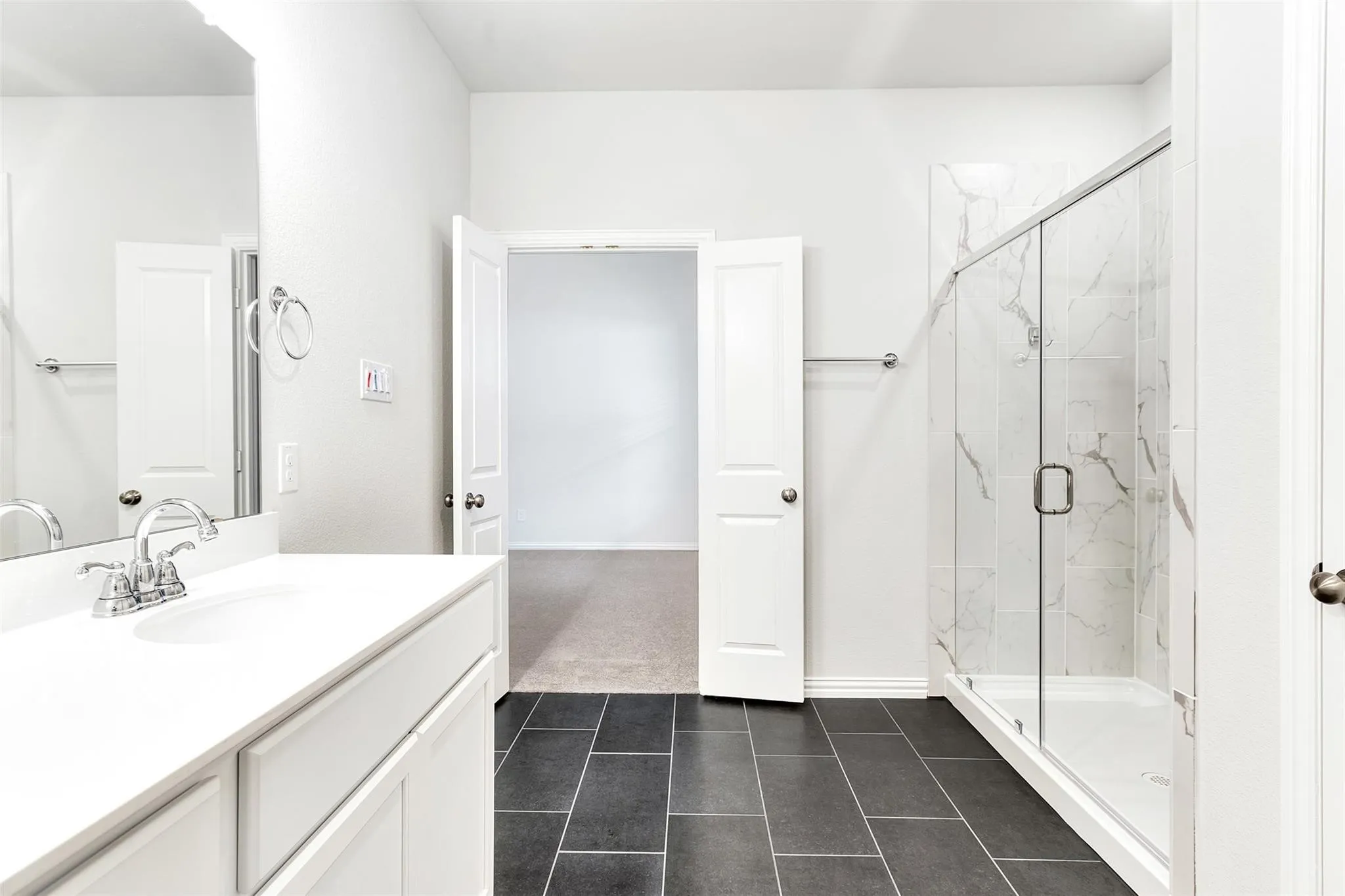 Primary bathroom with oversized shower, dual sinks, and separate linen closet