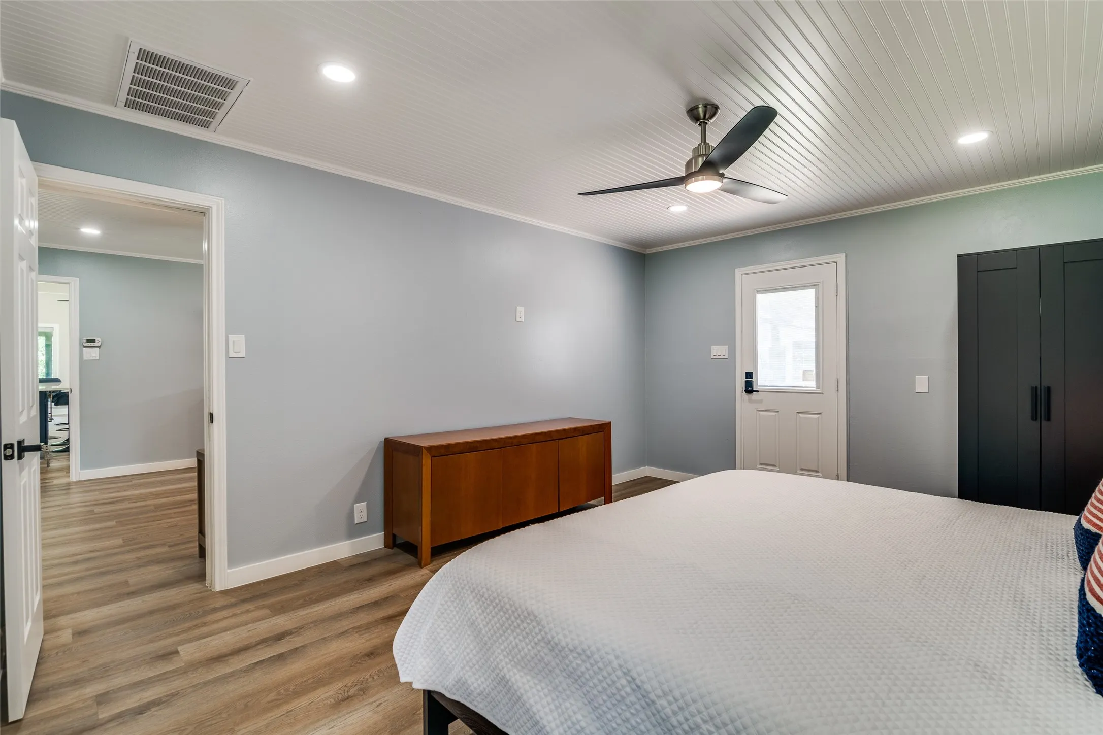 Wood-finish flooring, ceiling fan with integrated lighting, recessed lighting, white beadboard ceiling, and light blue wall finish