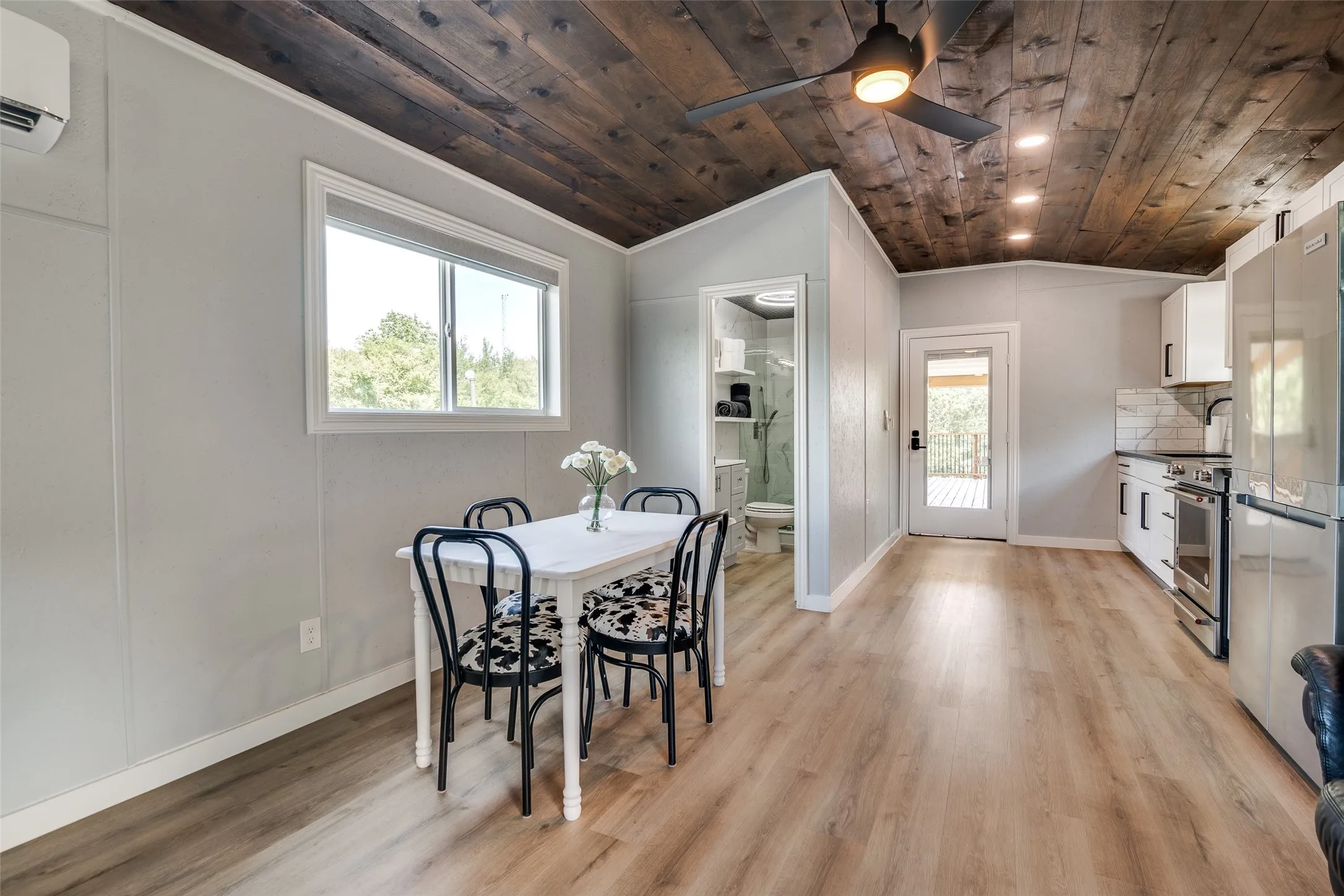 Wood-finish flooring throughout, with a wood panel ceiling, recessed lighting, and a ceiling fan