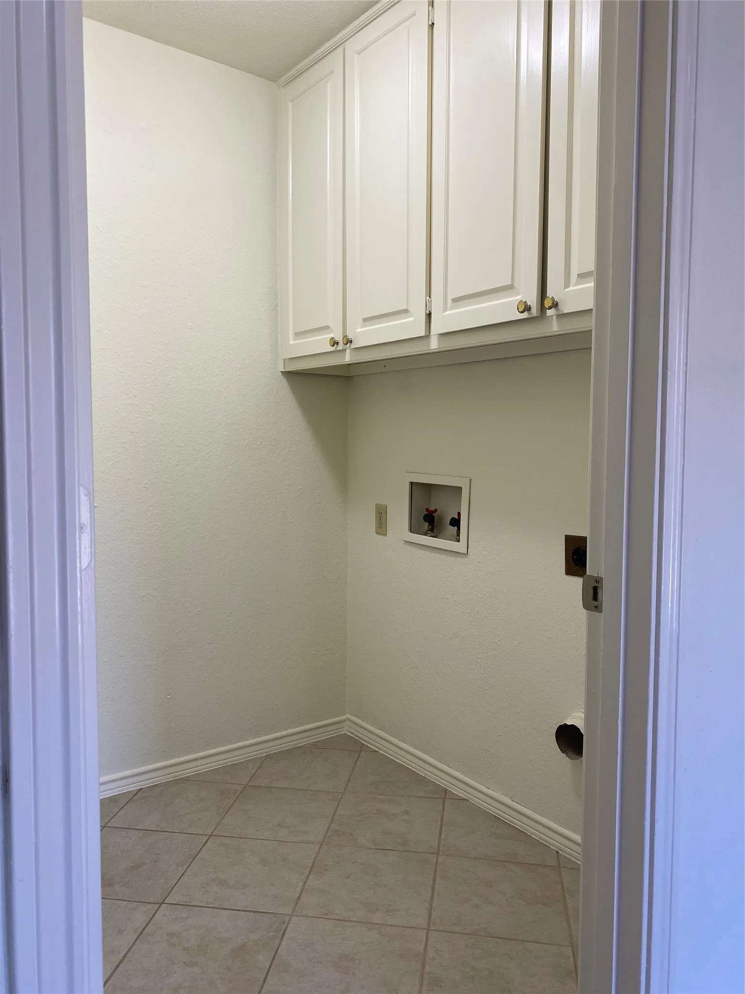 Separate Laundry has a door plus built in cabinets.