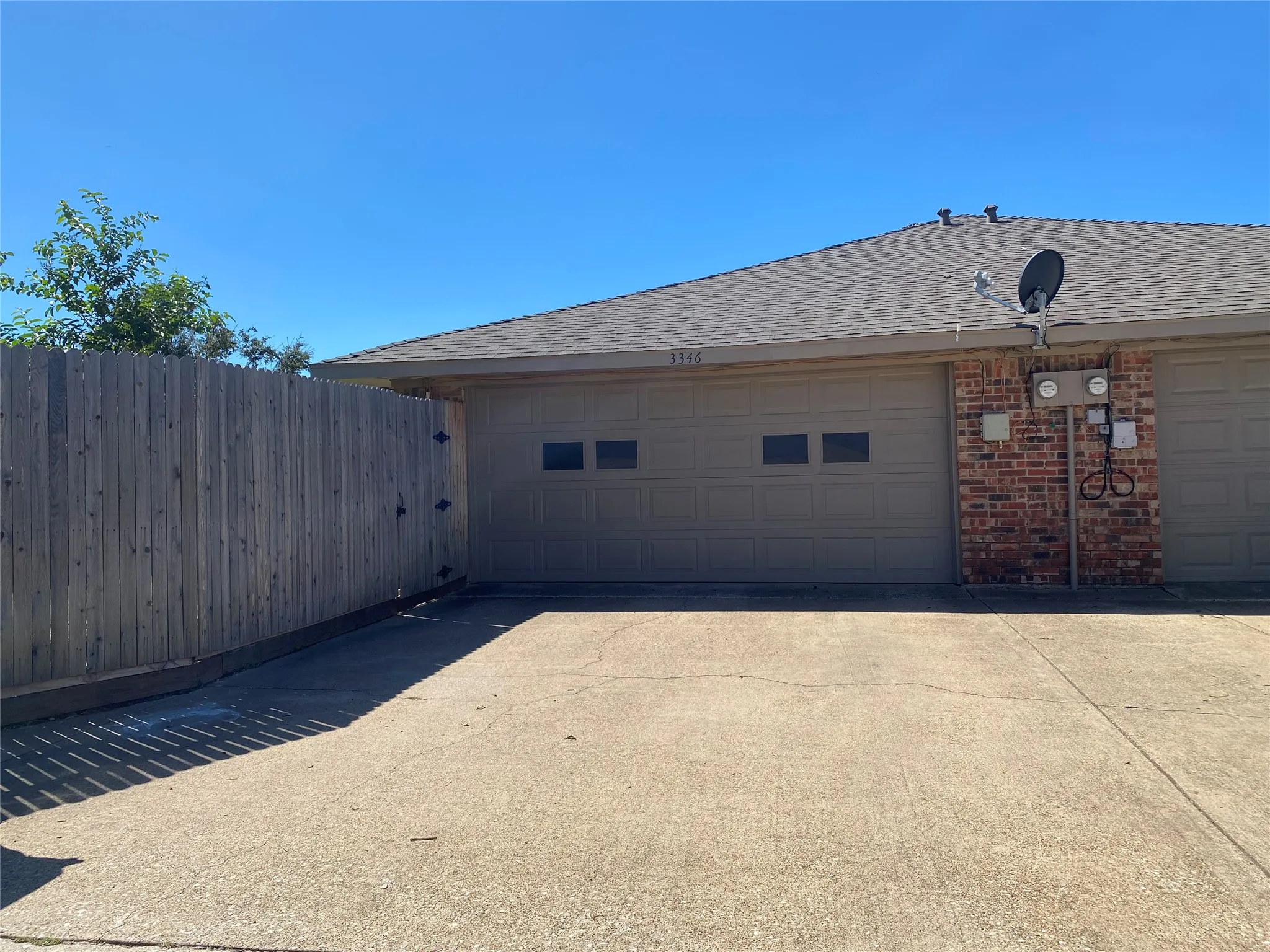 Large two car garage has a long flat driveway.