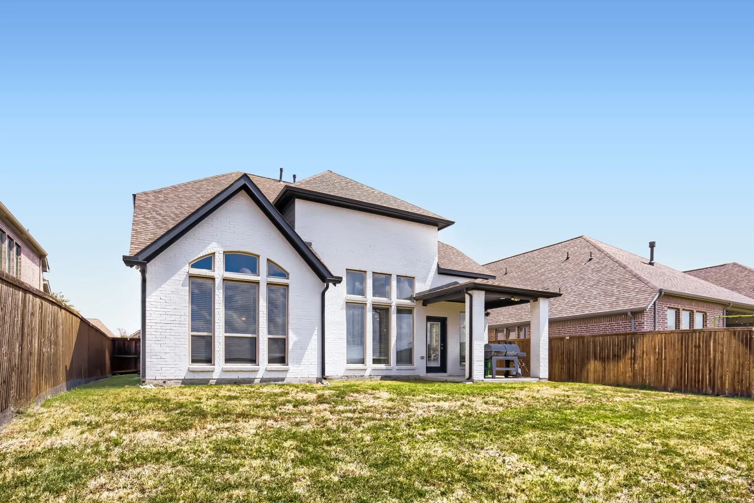 White brick exterior with dark trim and arched windows