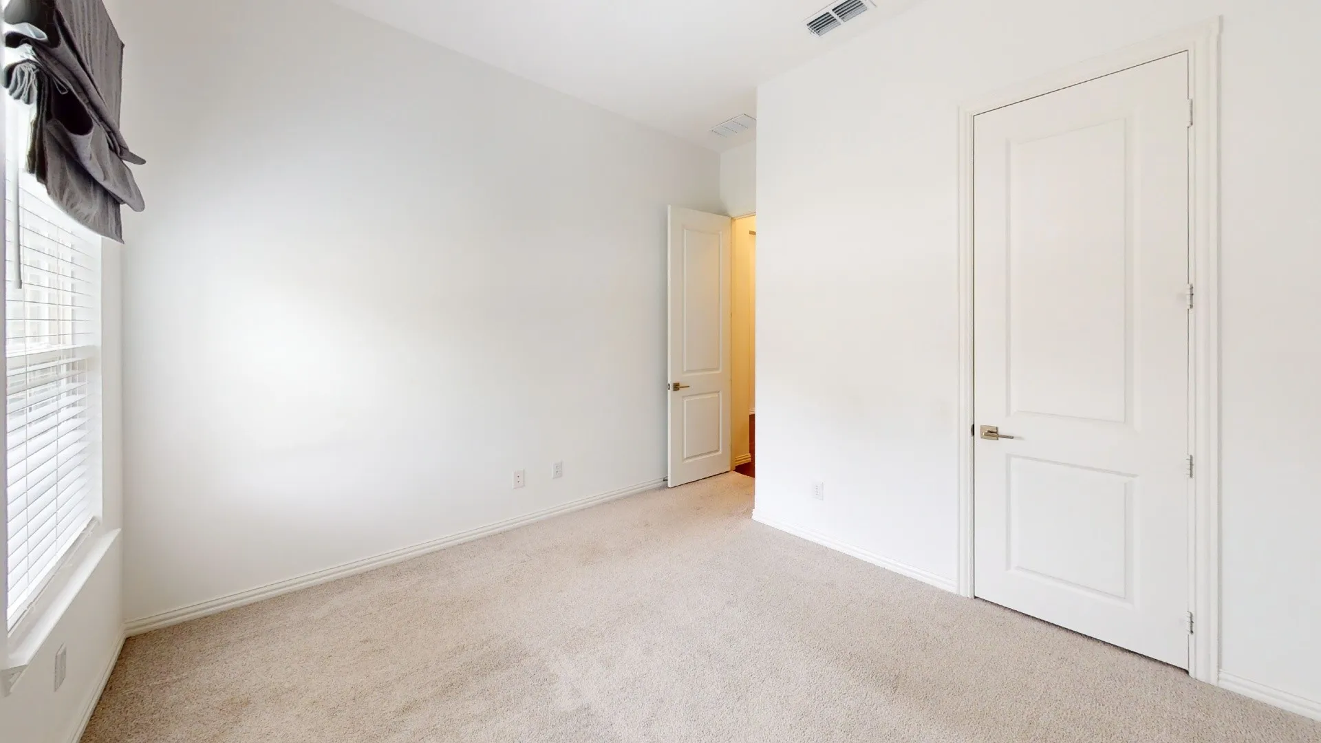 Carpeted flooring, white walls, white trim, recessed window, and white interior doors