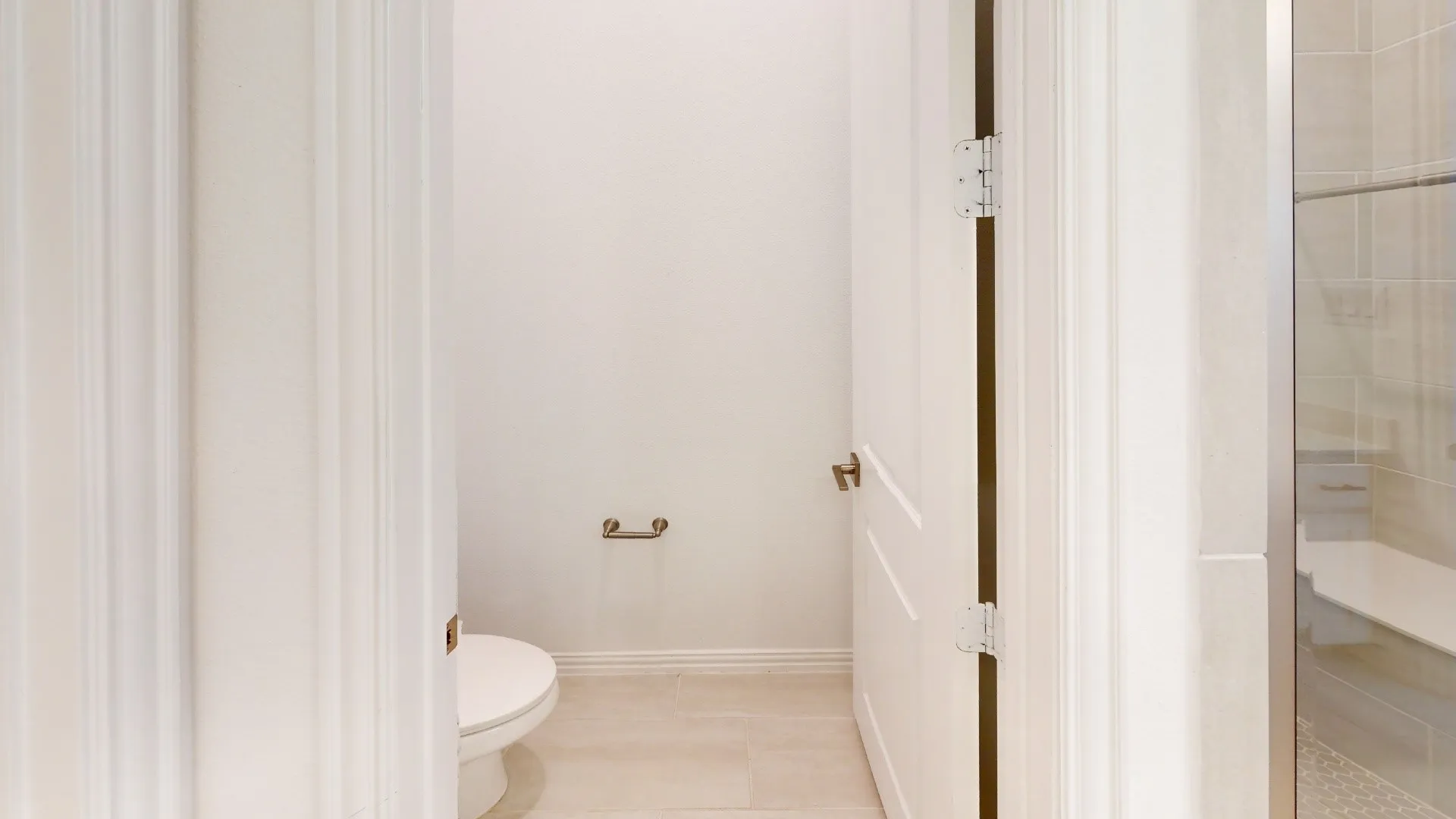Powder room featuring a toilet, tile flooring, and a glass-enclosed shower with a built-in bench