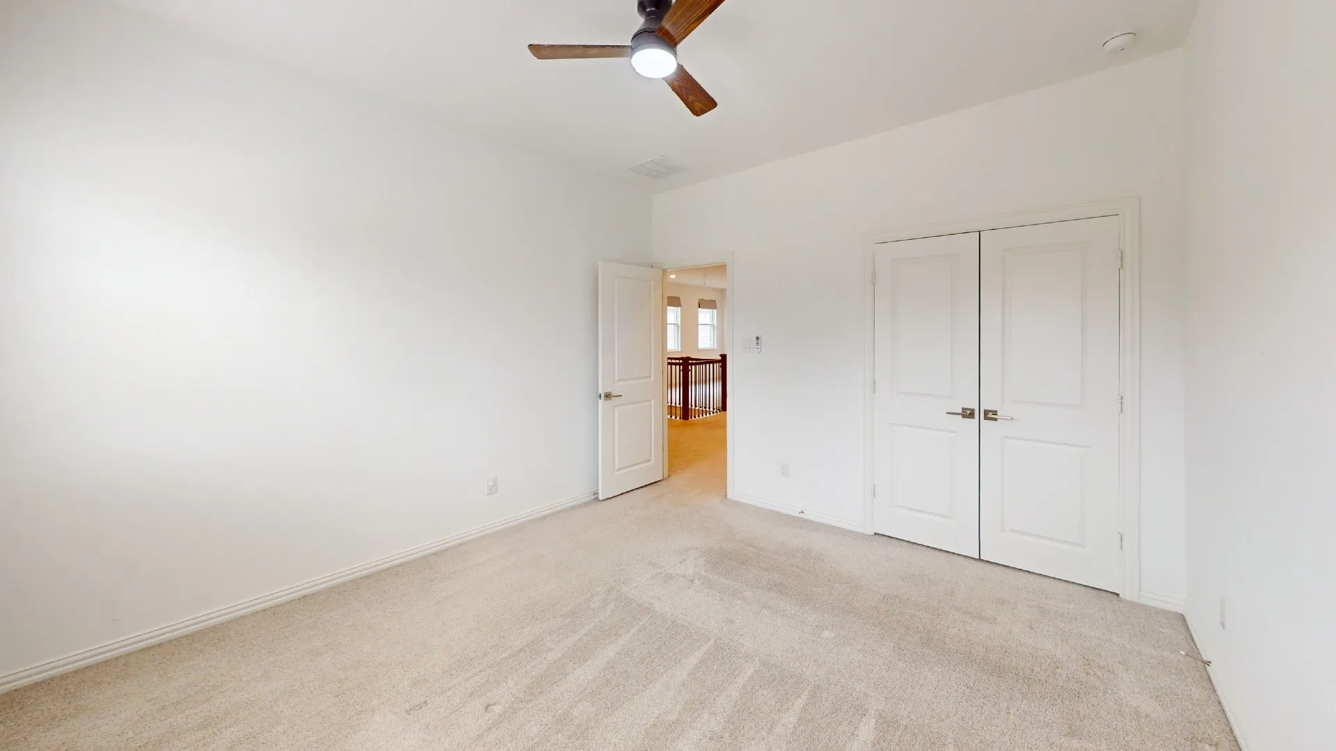 Neutral tone wall color, light-toned carpet, recessed ceiling lighting, ceiling fan, and double panel doors