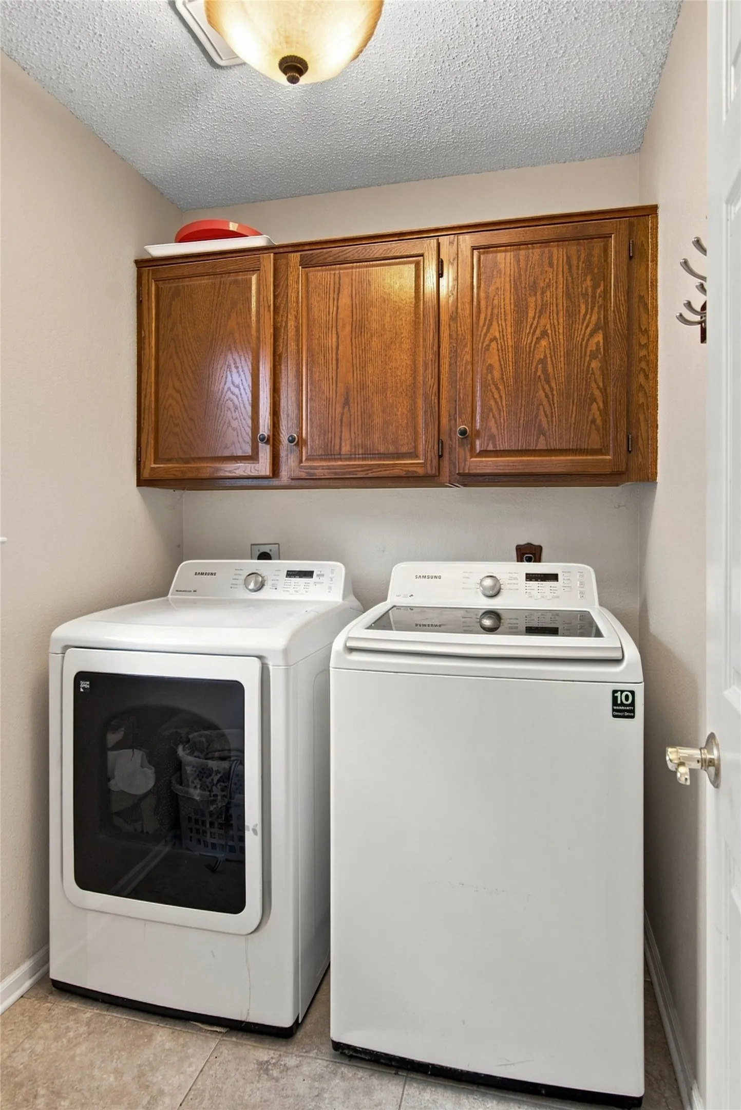 Utility room includes washer and dryer.  Storage cabinets