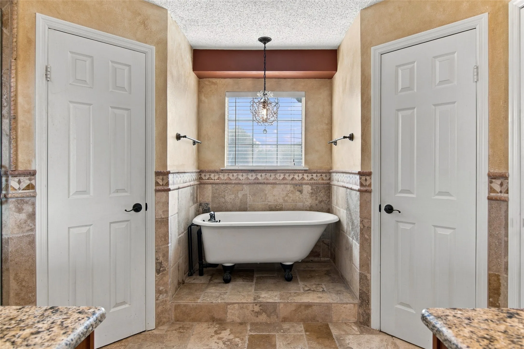 Master Bathroom with dual closets and antique style bathtub