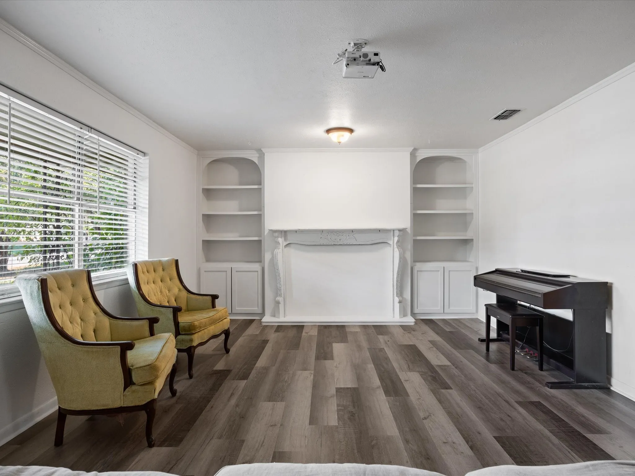 Wood-finish flooring throughout, built-in shelving, fireplace mantel, and recessed lighting