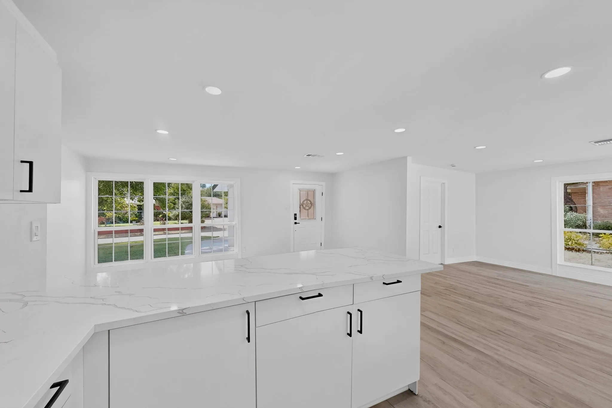 Kitchen island with a light-toned countertop and white cabinetry