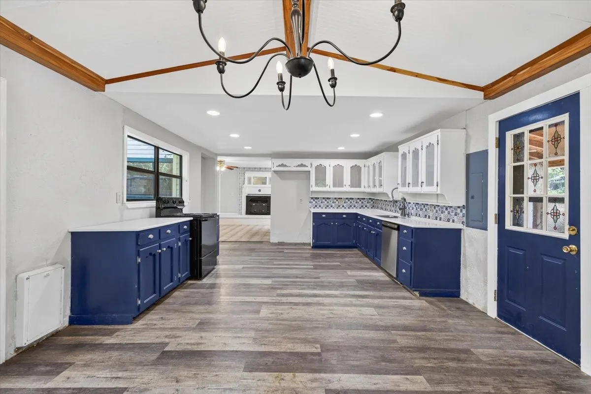 Kitchen featuring wood-finish flooring, exposed wood beams, and a black chandelier
