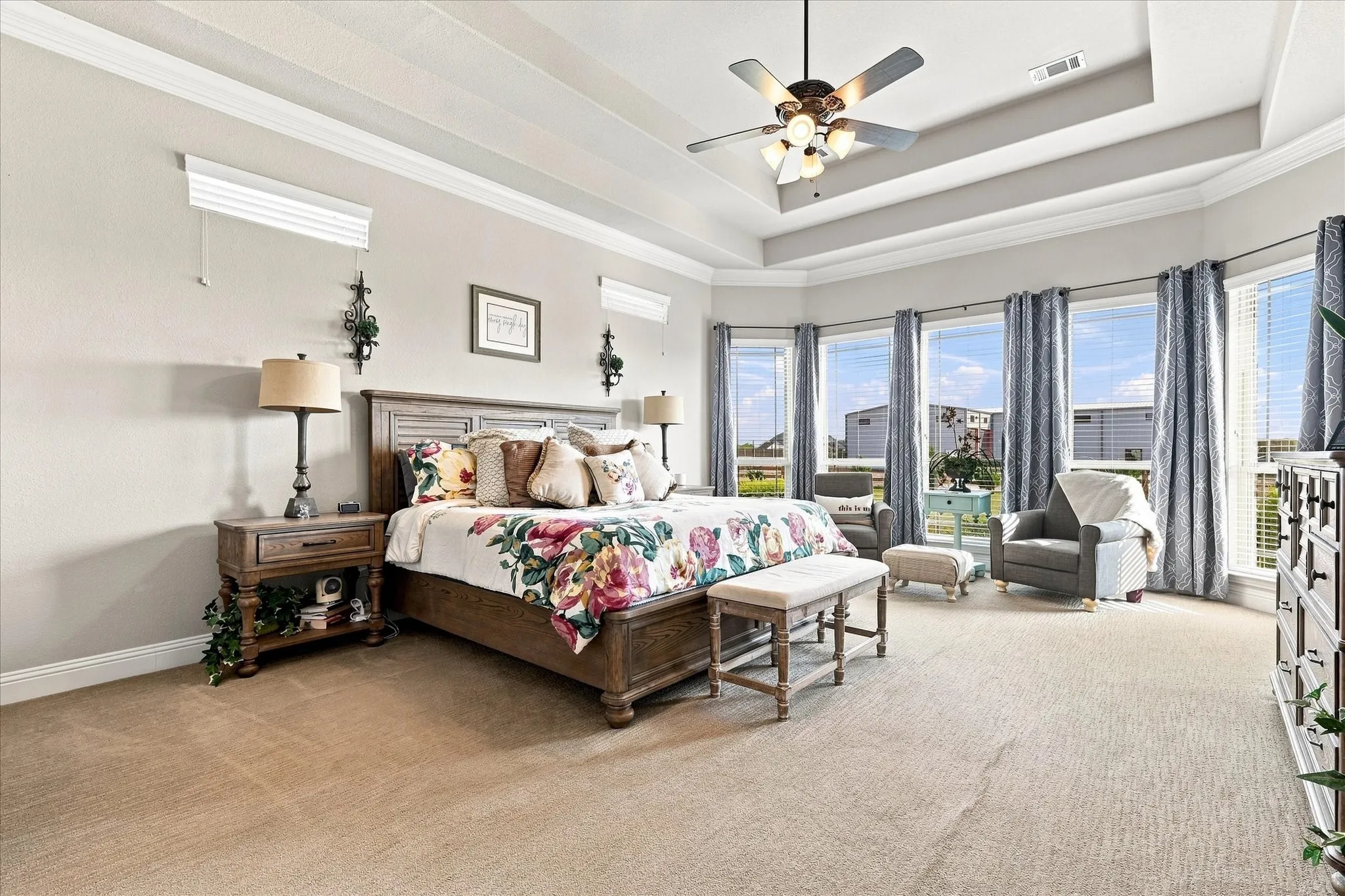 Tray ceiling with crown molding, ceiling fan, and recessed lighting