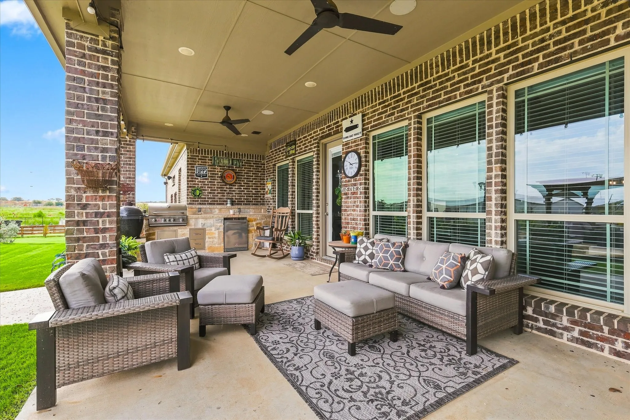 Covered patio featuring a brick exterior, recessed lighting, ceiling fans, and an outdoor kitchen with built-in grill