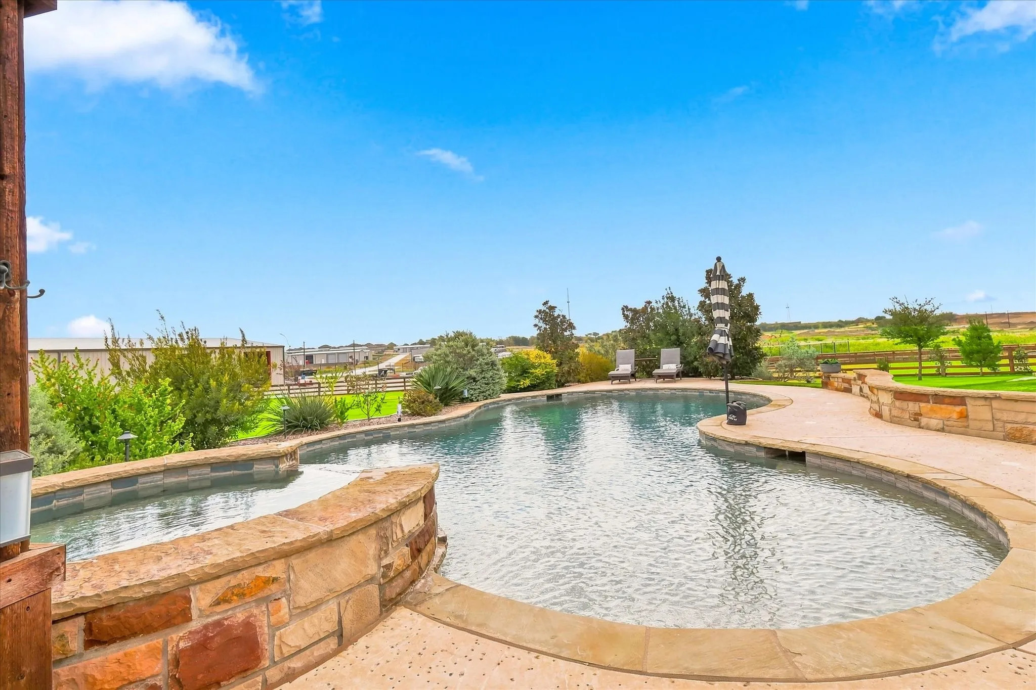 Freeform swimming pool with integrated spa and stone surround
