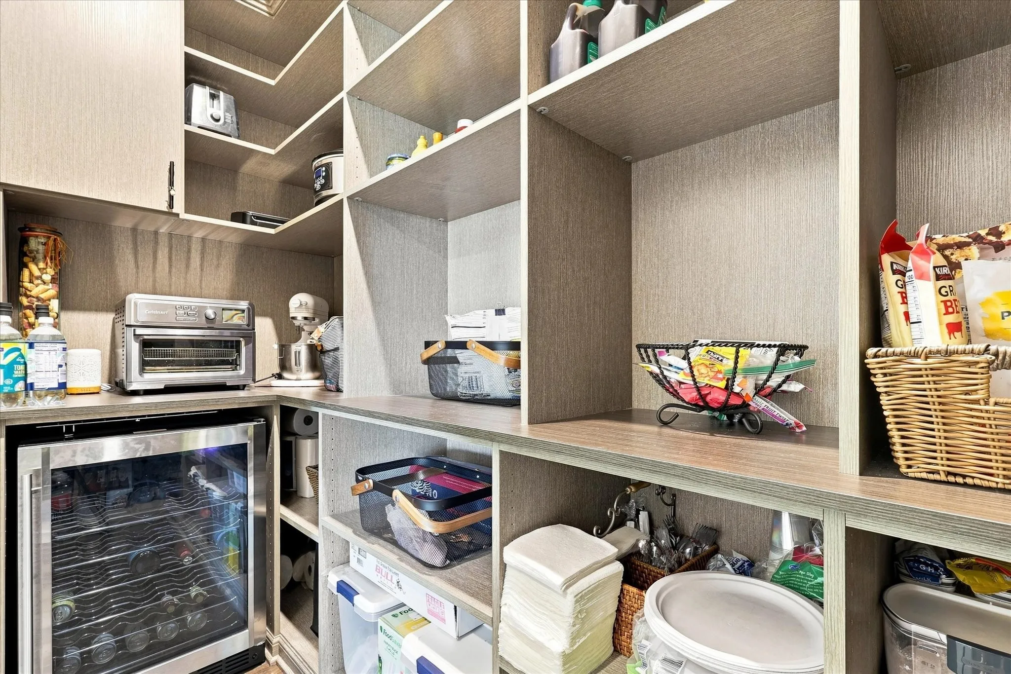 Built-in shelving with multiple compartments, integrated under-counter beverage cooler, and durable countertop space