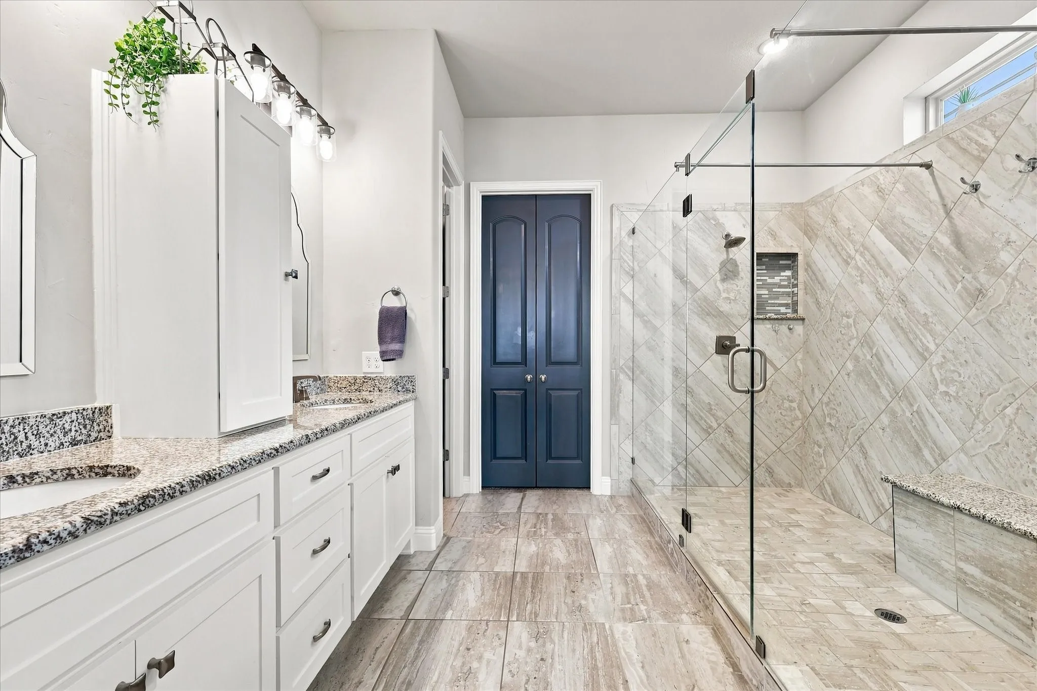 Walk-in shower with glass enclosure, integrated bench seating, and tiled walls