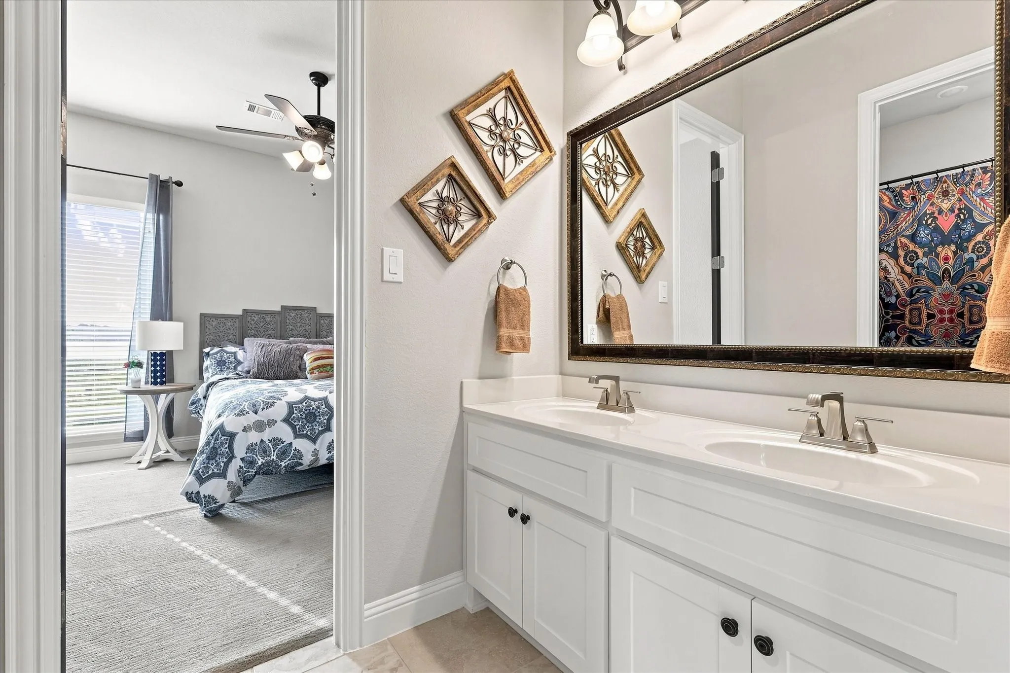 Dual vanity with white cabinetry, brushed nickel faucets, and a large framed mirror