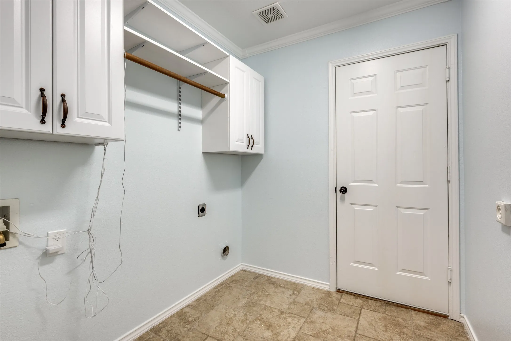 White cabinetry, built-in shelving, hanging rod, panel door, and tile flooring