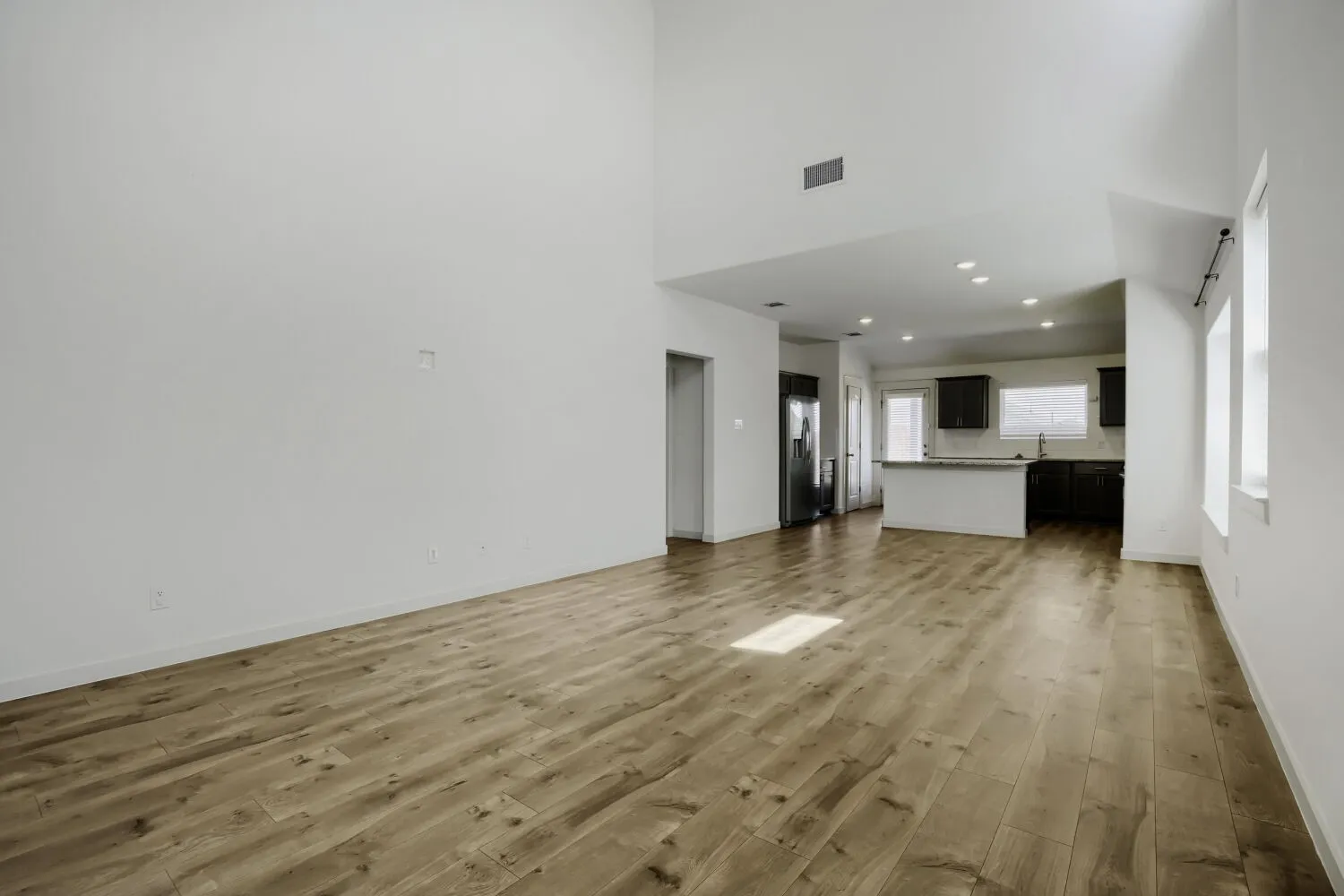 Vaulted ceilings, wood-finish flooring, recessed lighting, kitchen island with countertop, and dark wood-finish cabinetry