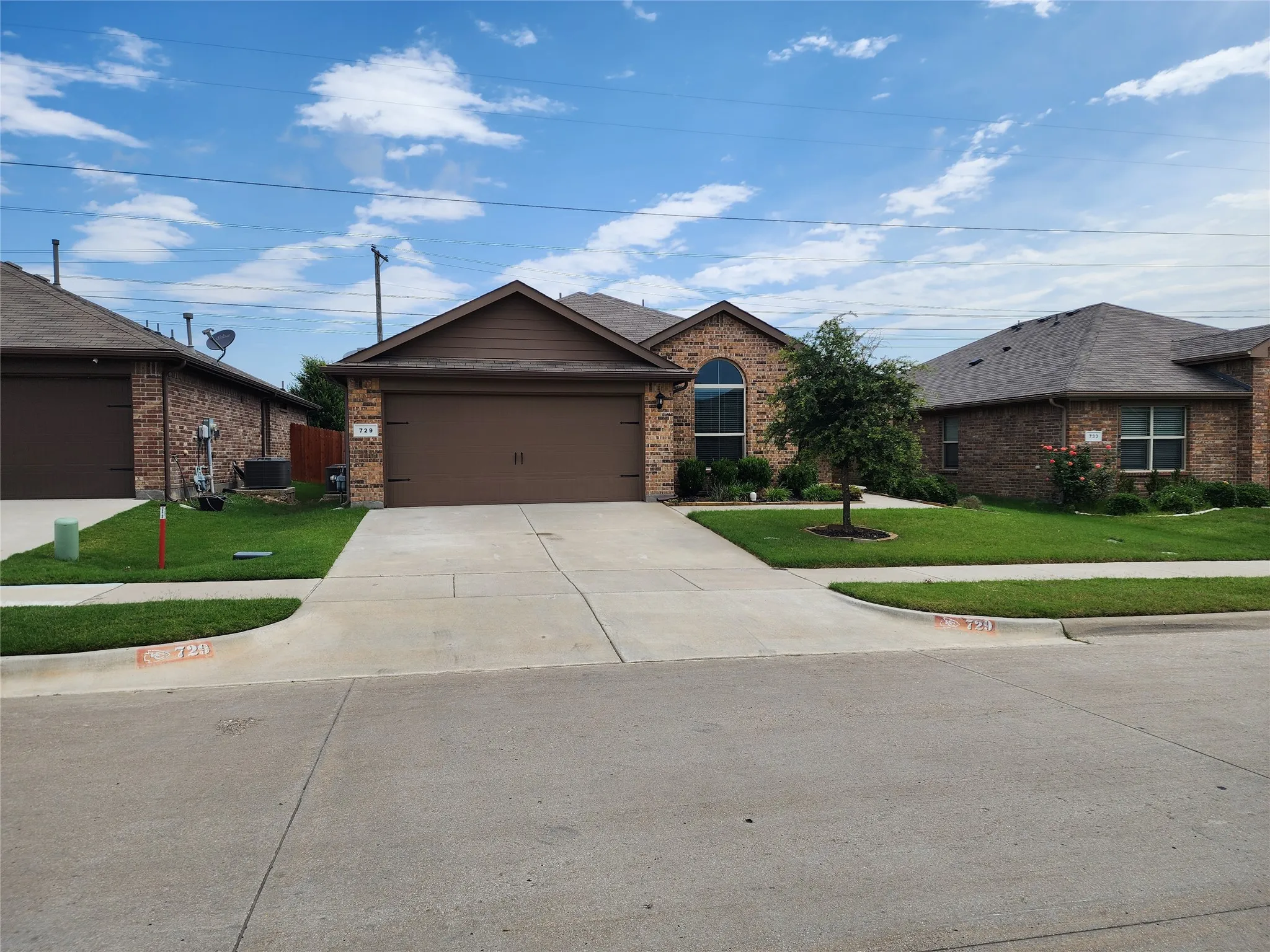 Ranch-style home with a front lawn, a garage, and central air condition unit