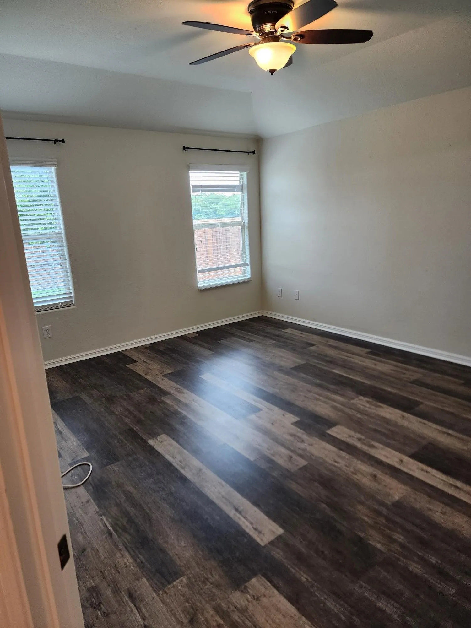 Unfurnished room with ceiling fan and dark wood-type flooring