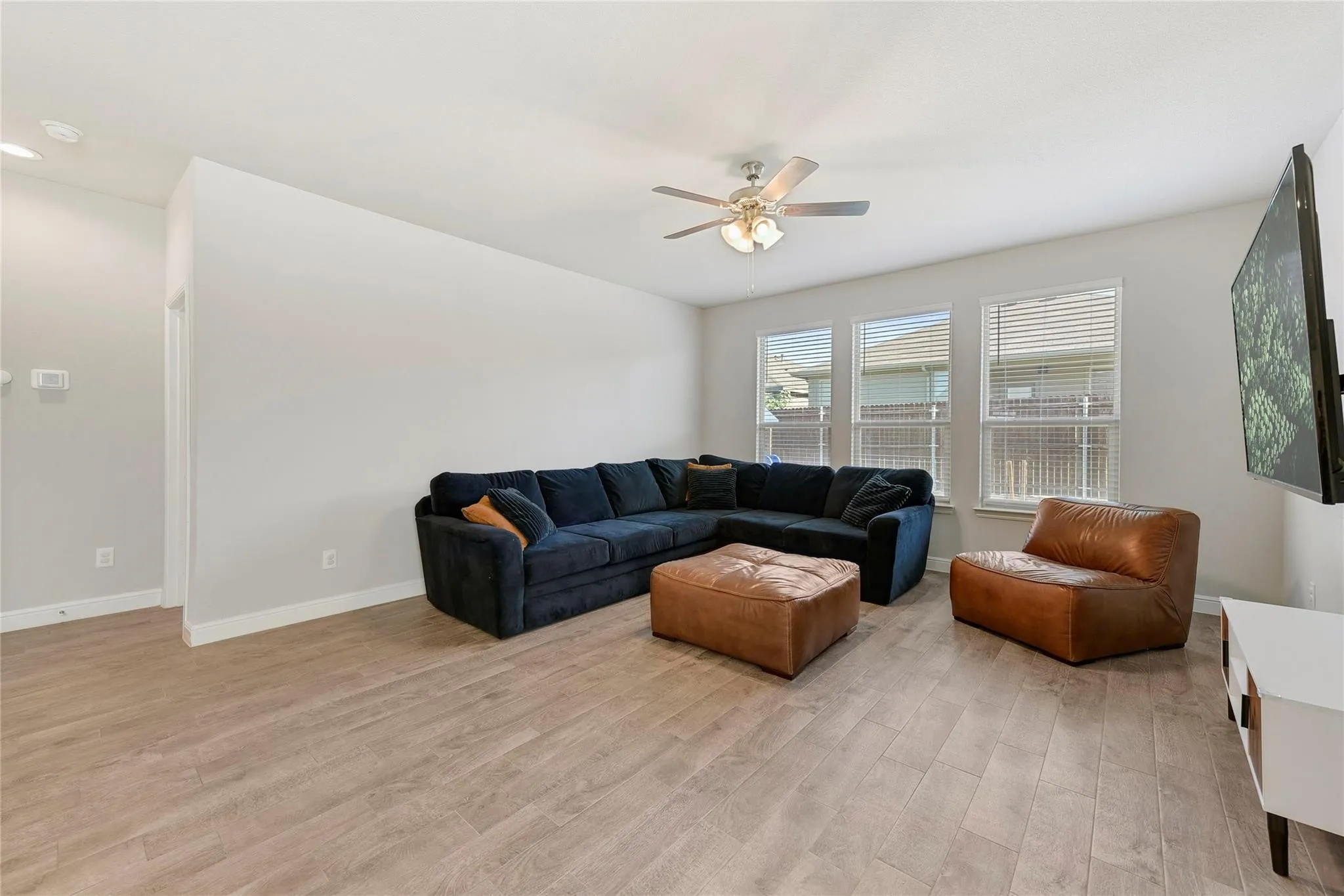 Living room with ceiling fan and light hardwood / wood-style flooring