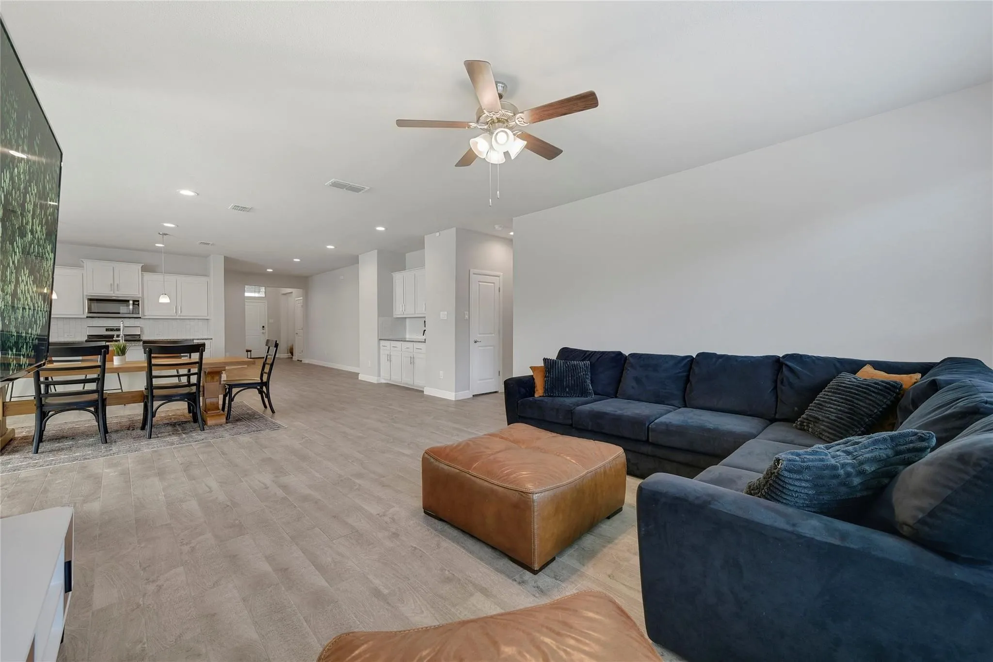 Living room with light wood-type flooring and ceiling fan