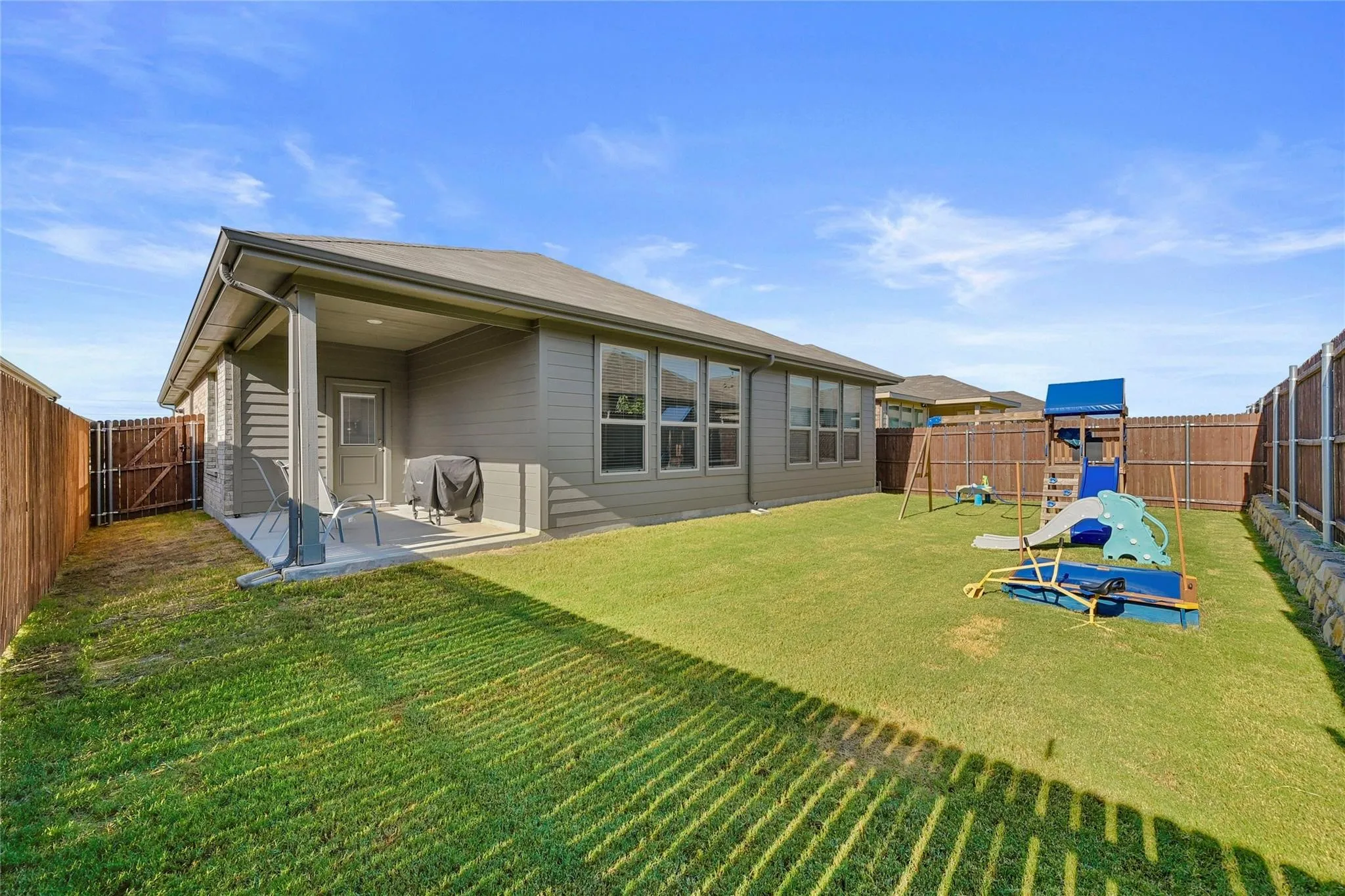 Back of property featuring a patio and a lawn