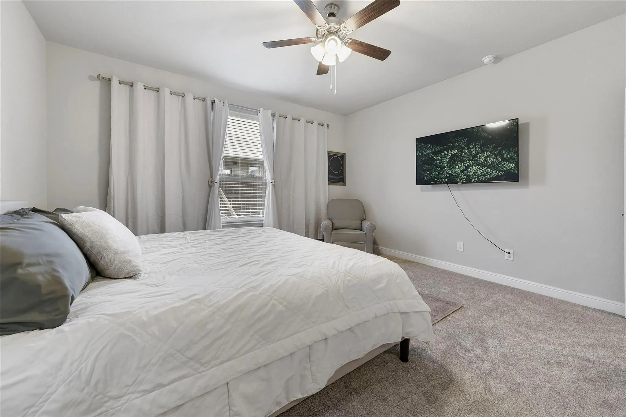 Carpeted bedroom featuring ceiling fan