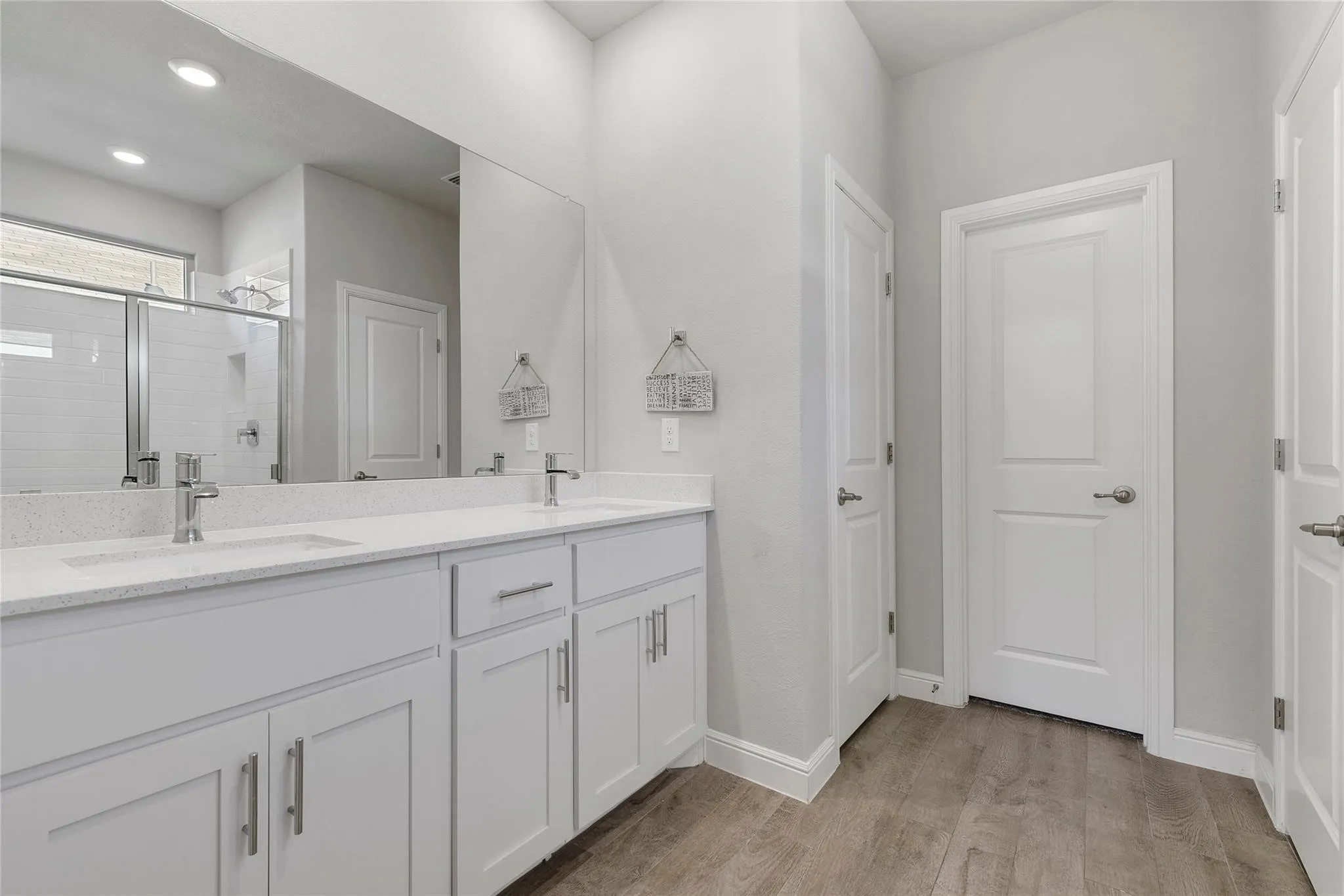 Bathroom featuring walk in shower, vanity, and hardwood / wood-style flooring