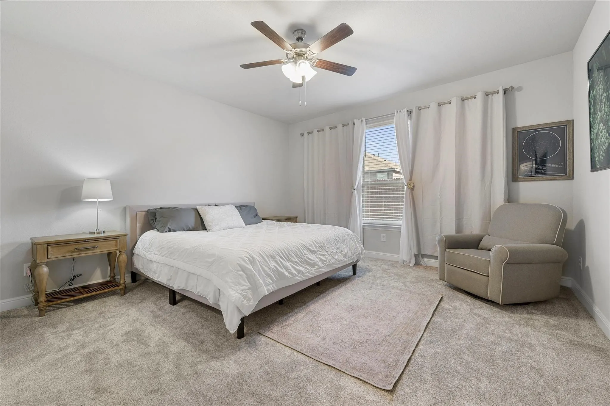 Bedroom with light colored carpet and ceiling fan