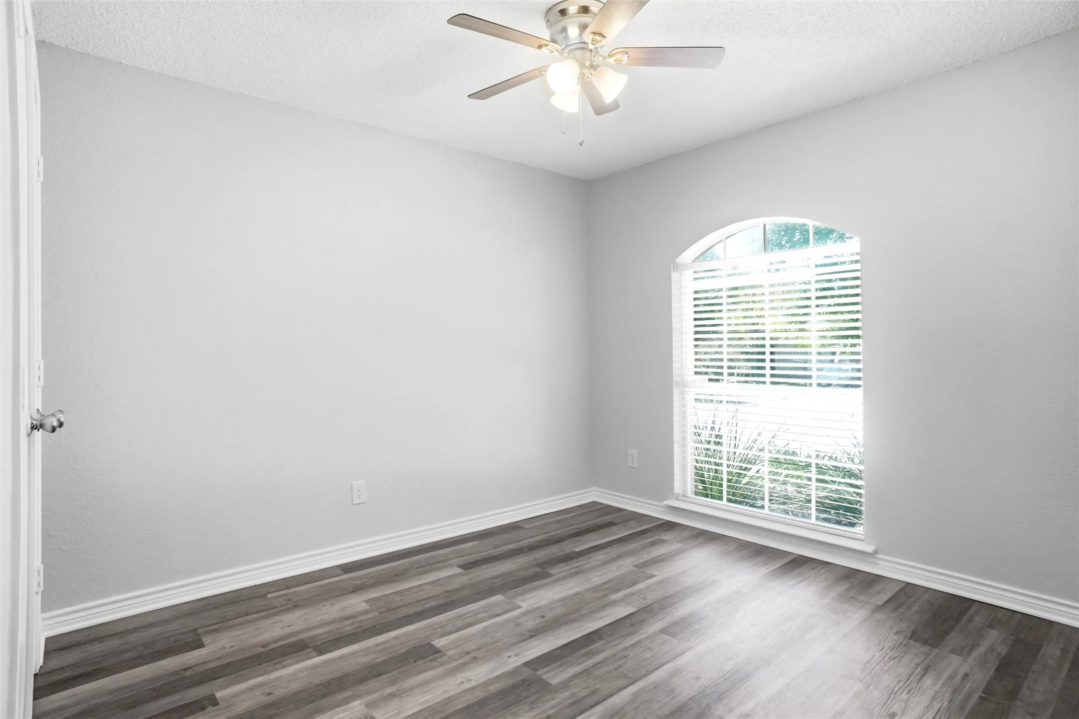 Arch-top window with blinds, ceiling fan with integrated lighting