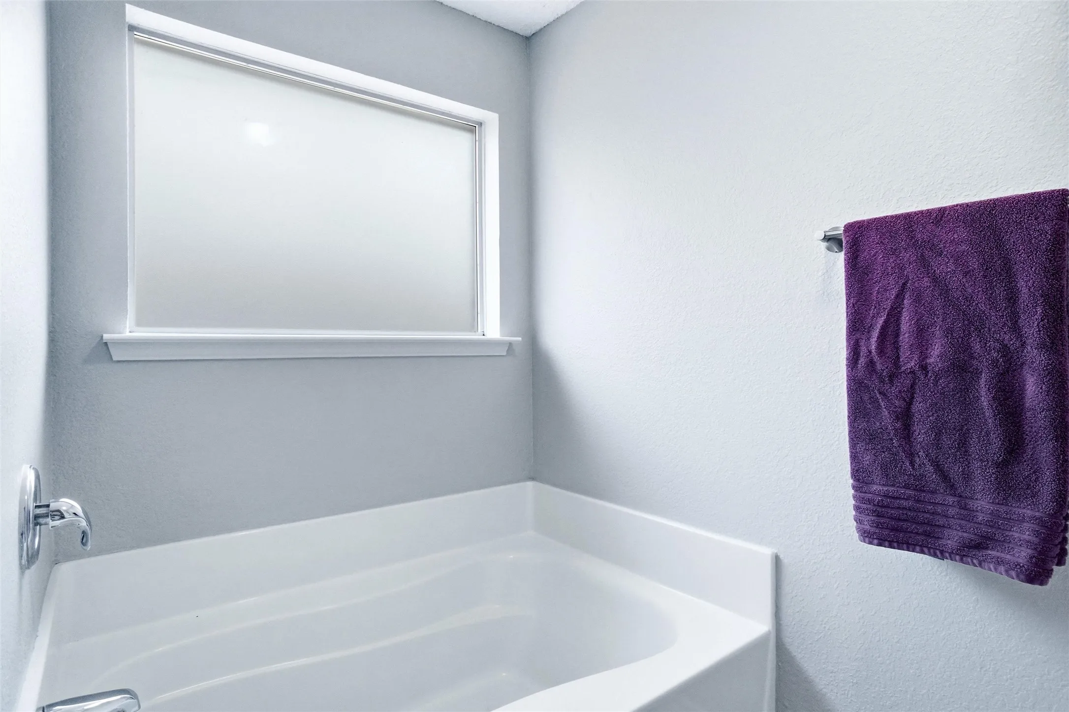 Deep soaking tub with chrome fixtures and privacy window