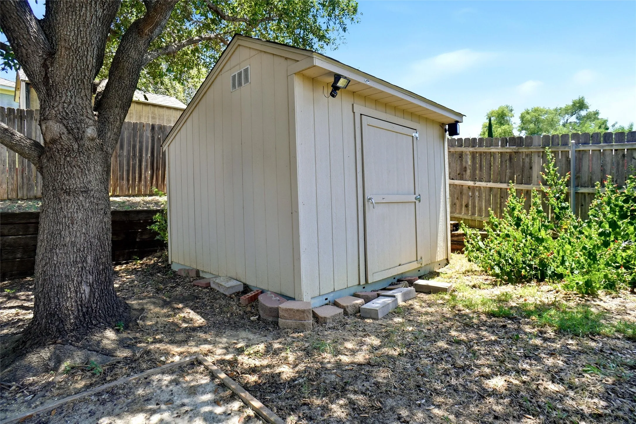 Exterior storage shed with a gable roof, board and batten siding, and a single paneled door