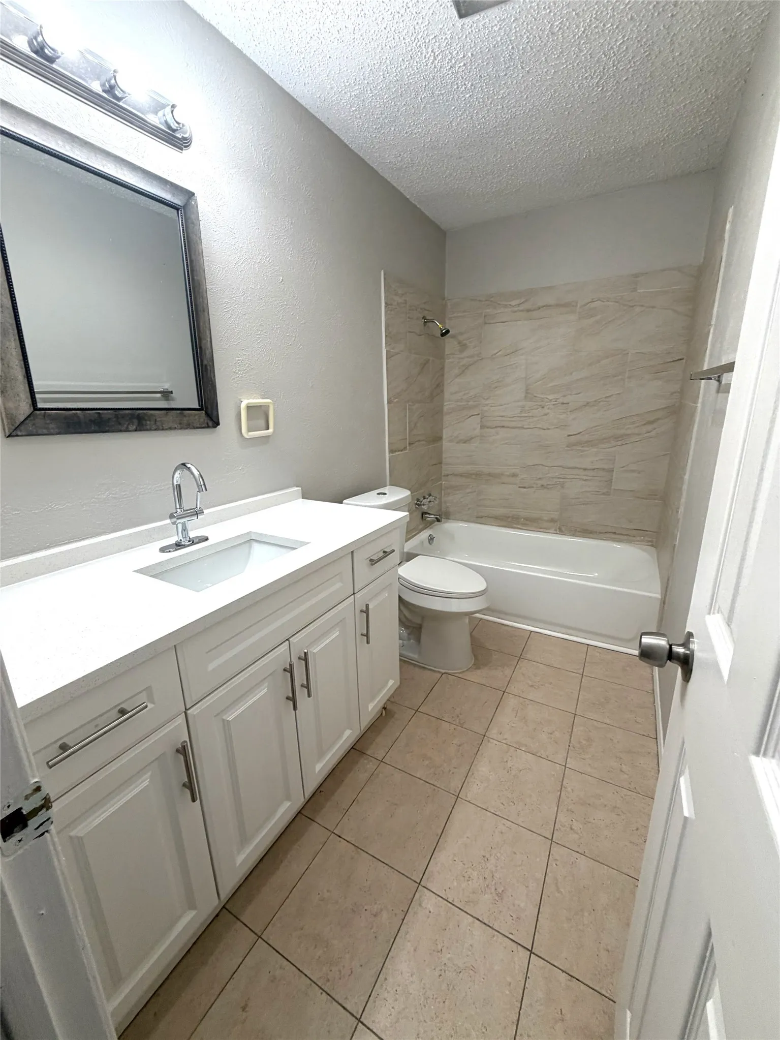 White vanity with brushed nickel hardware, integrated sink, and light-toned countertop